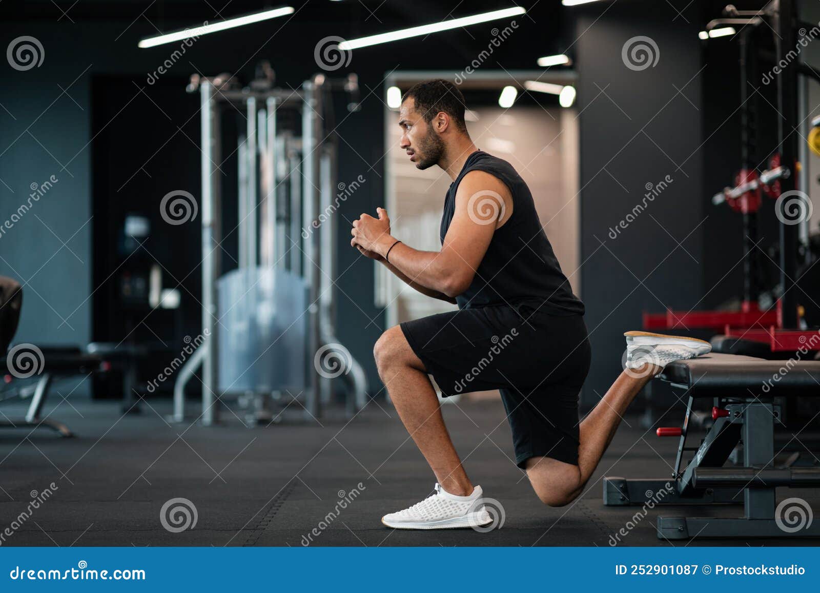 portrait of athletic black man making bulgarian split squat exercise at gym