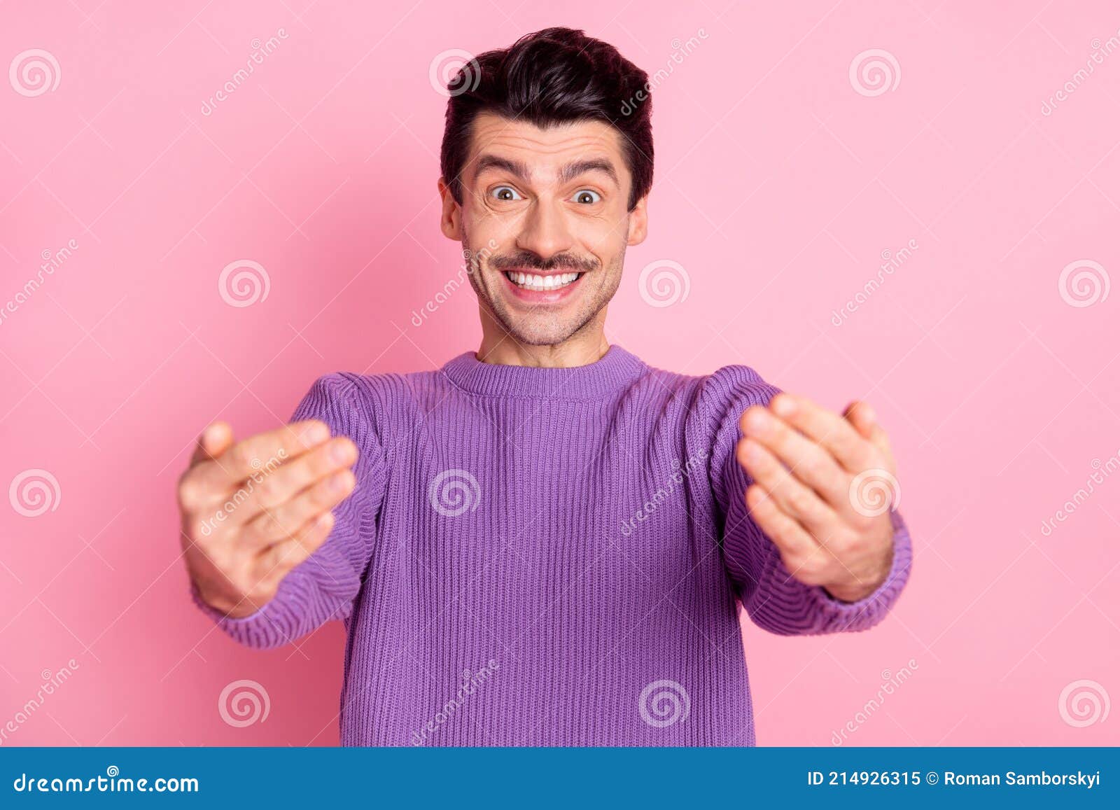 portrait of attractive cheerful friendly guy calling you come here to me  over pink pastel color background