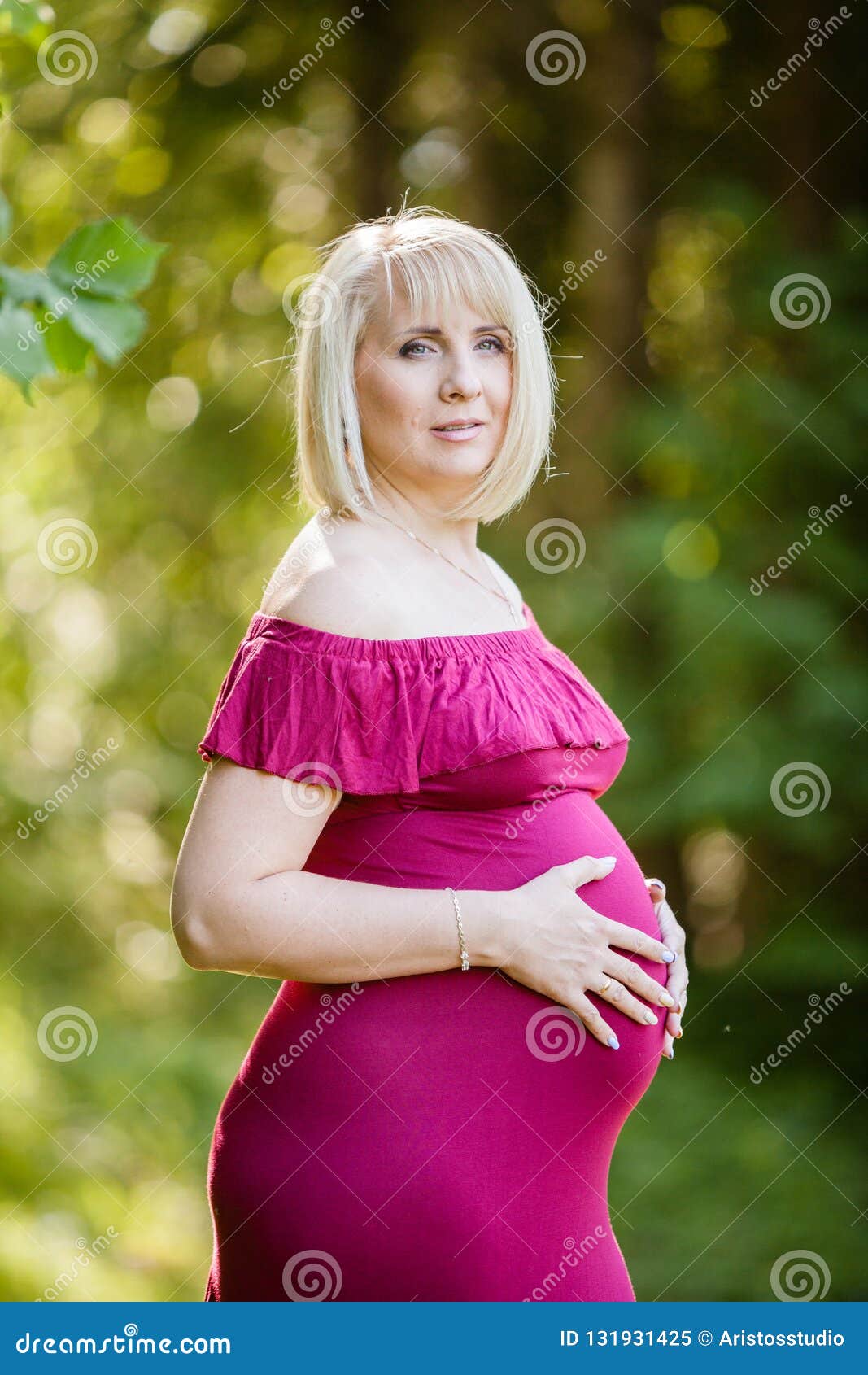 Beautiful Pregnant Woman In Stylish Long Purple Maternity Dress With Ruffles Looking Dreamy In