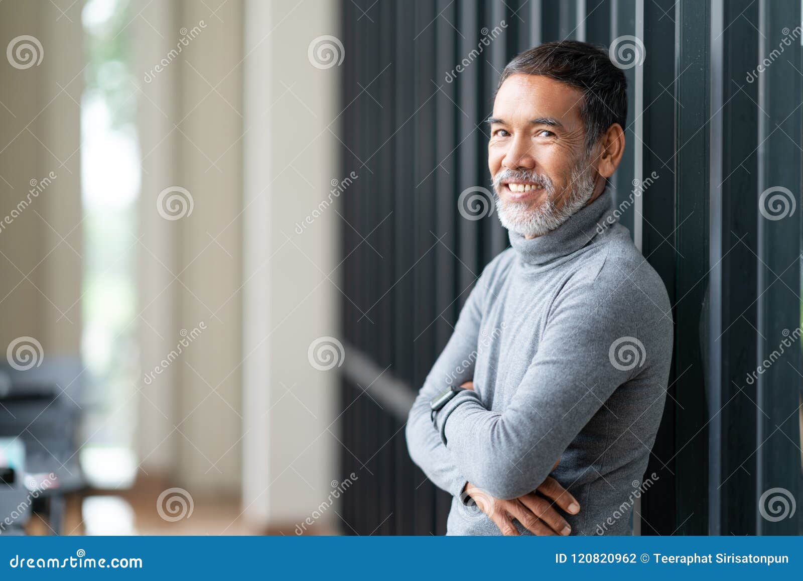 portrait attractive mature asian man retired with stylish short beard smiling at coffee shop outdoor.