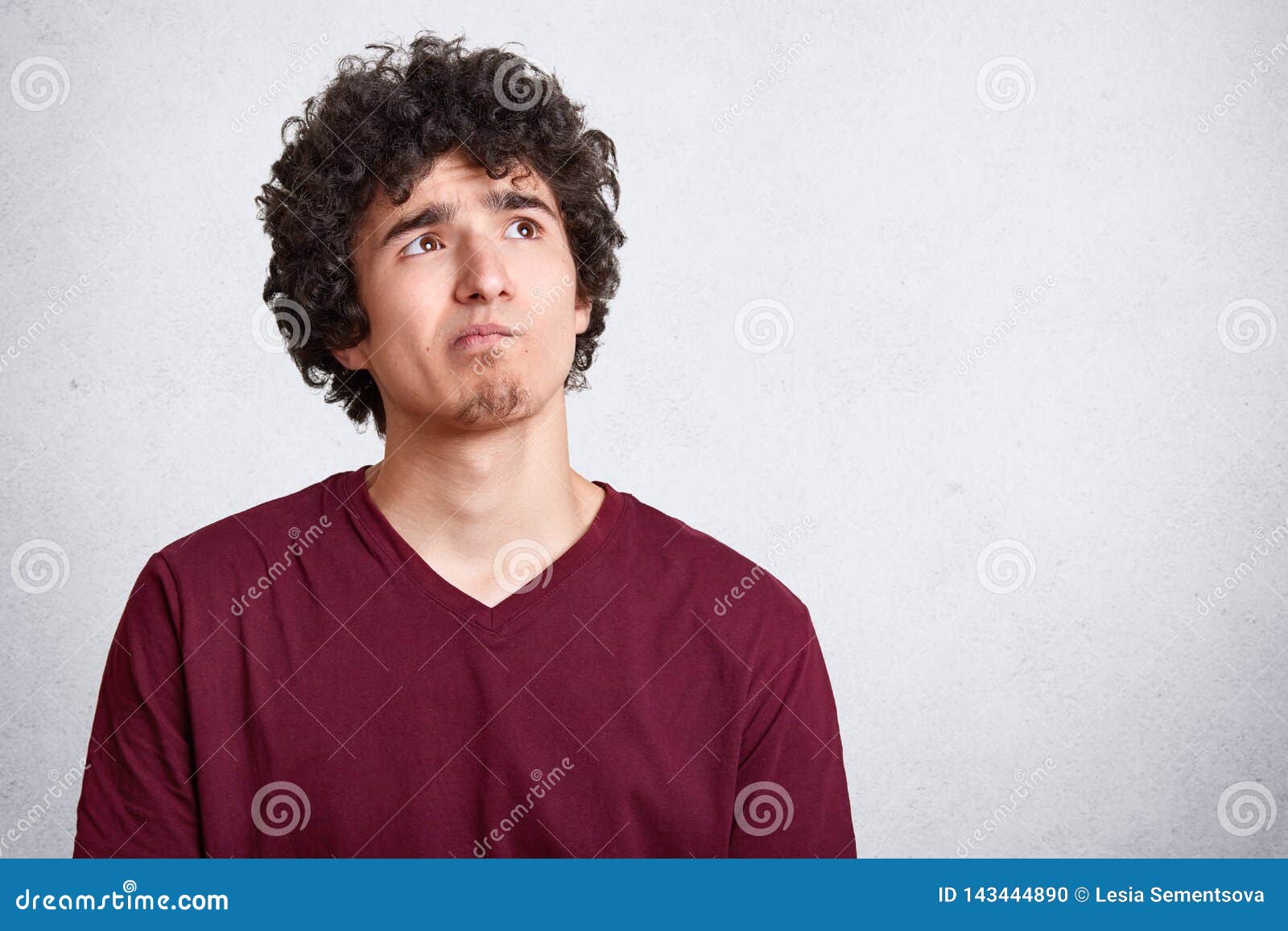 Portrait of Attractive Young Man with Curly Hair Thoughtfully Looking at  Right Upper Corner Over White Background. Pensive Guy in Stock Photo -  Image of copyspace, people: 143444890