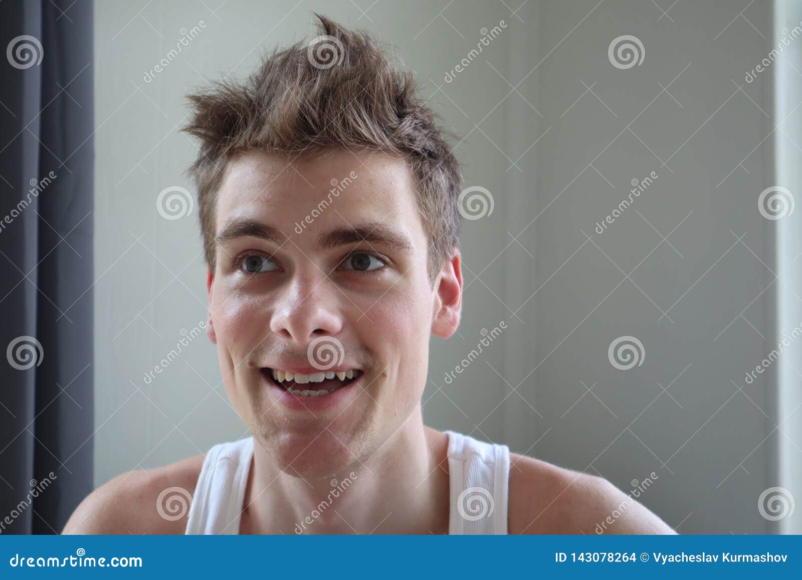 portrait of attractive young man with satisfied expression. white background. emotional portrait. clear skin and short hair. young
