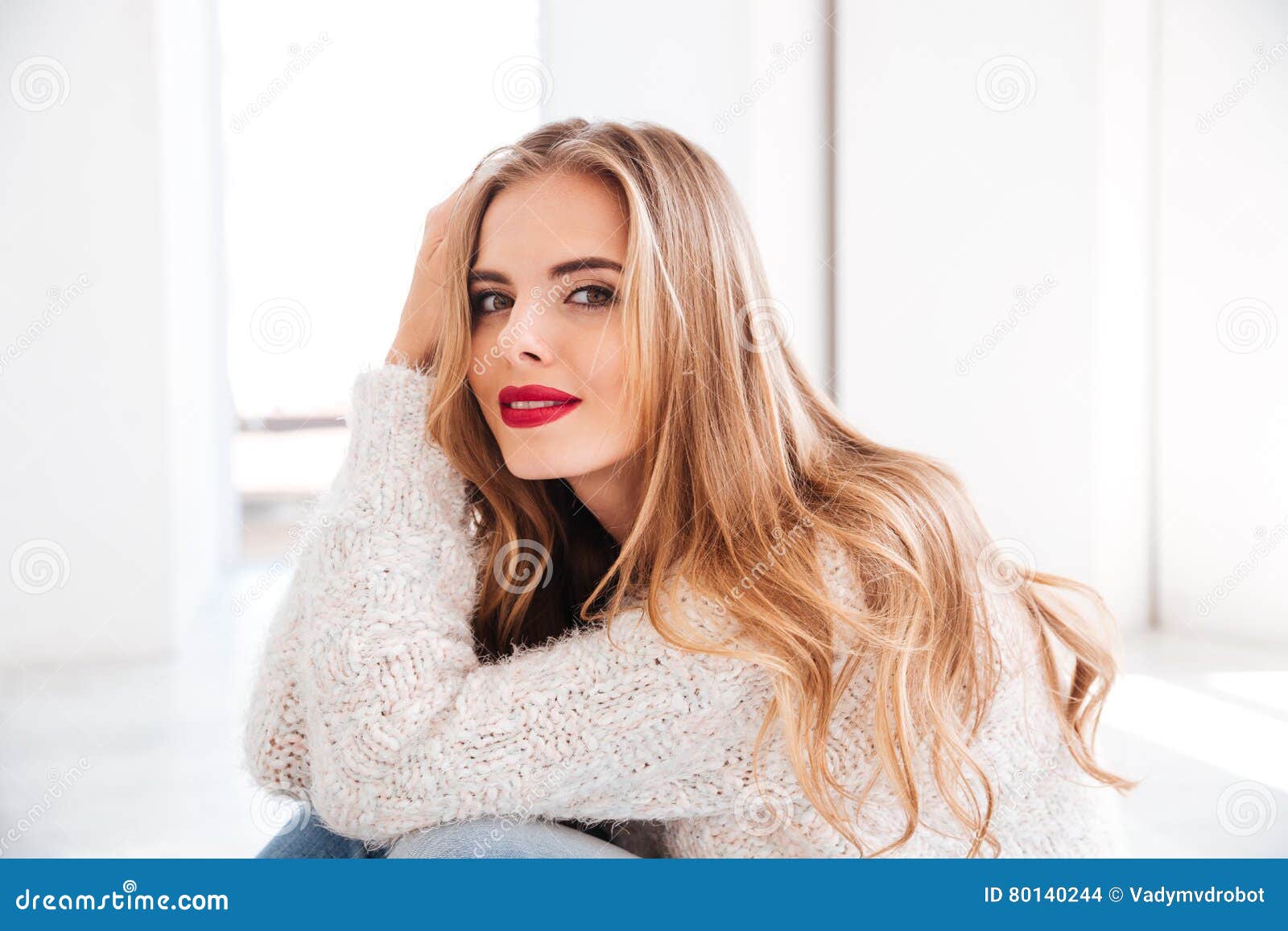 portrait of attractive young woman wearing sweater and red lipstick