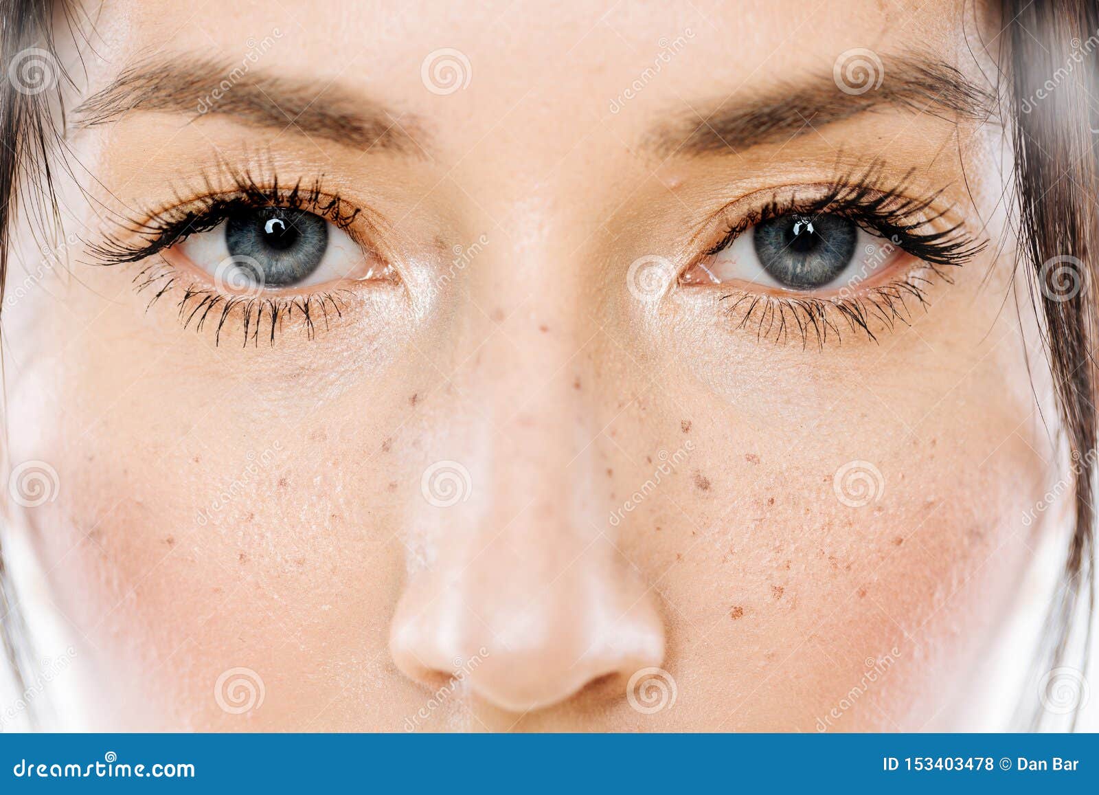 portrait of beautiful brunette woman model with freckles and blue eyes