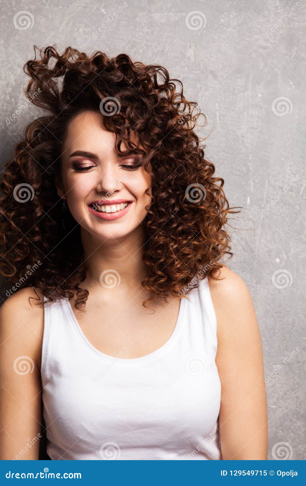 Portrait Of Beautiful Cheerful Girl With Flying Curly Hair Smiling Laughing Looking At Camera