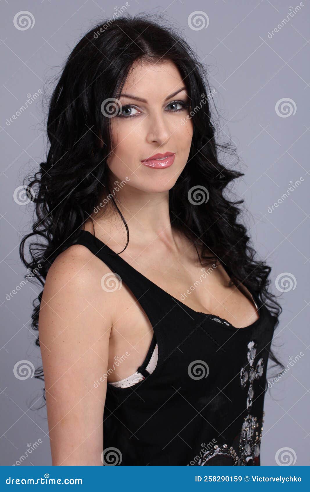 Portrait of a Beautiful Fashion Girl Brunette with Big Breasts in the  Studio in a Nice Black Expencive Dress on a Gray Background Stock Image -  Image of high, beauty: 258290159