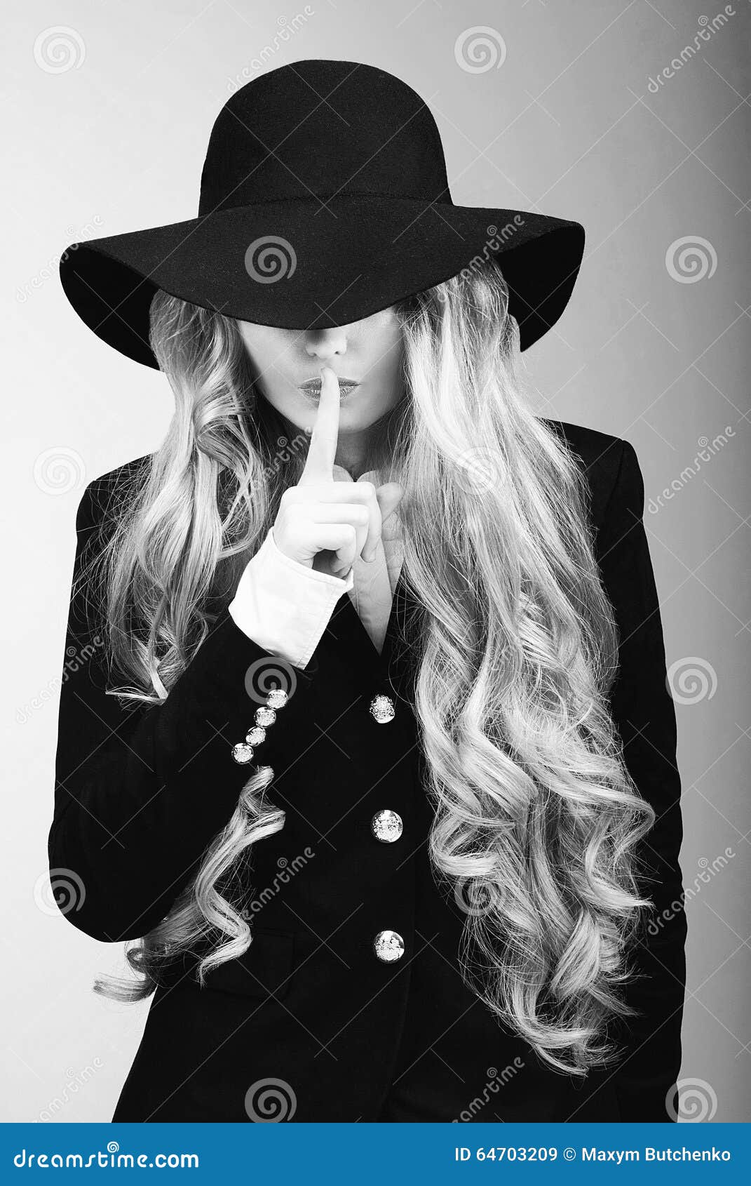 Woman in black and white hat holding black and white stick photo
