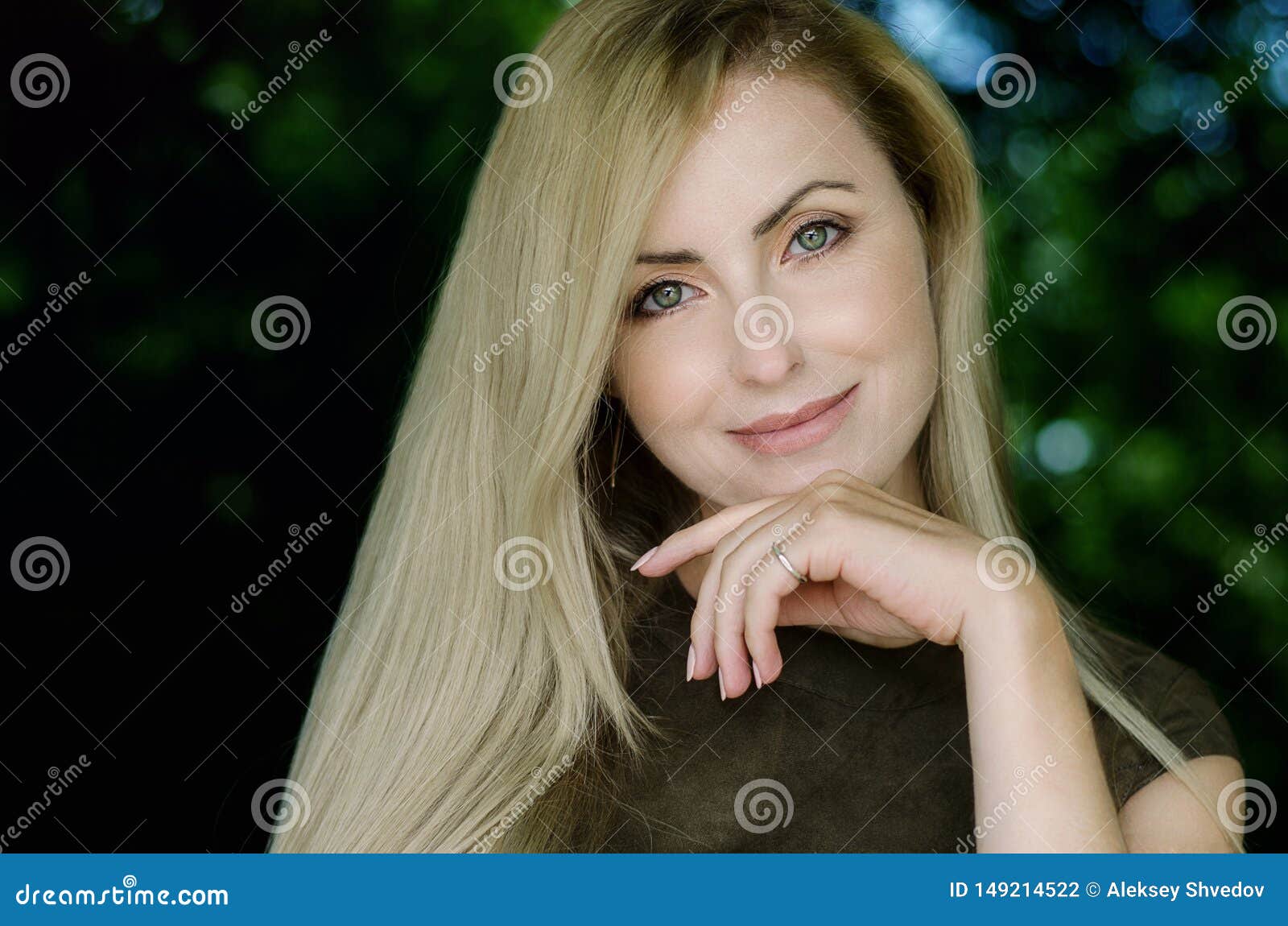 Portrait of a smiling girl in green foliage. Portrait of a beautiful girl