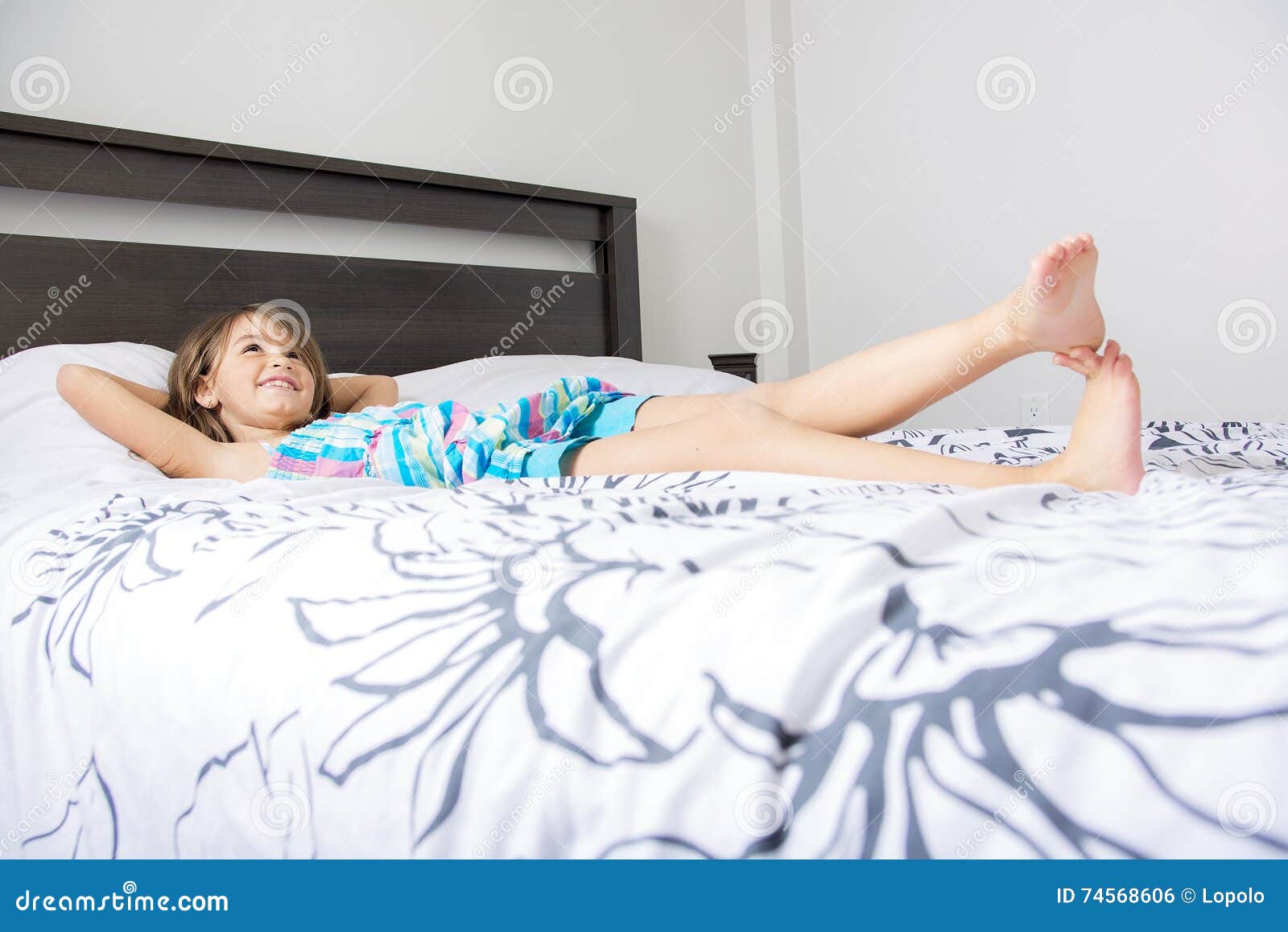 portrait of beautiful little girl lying on bed