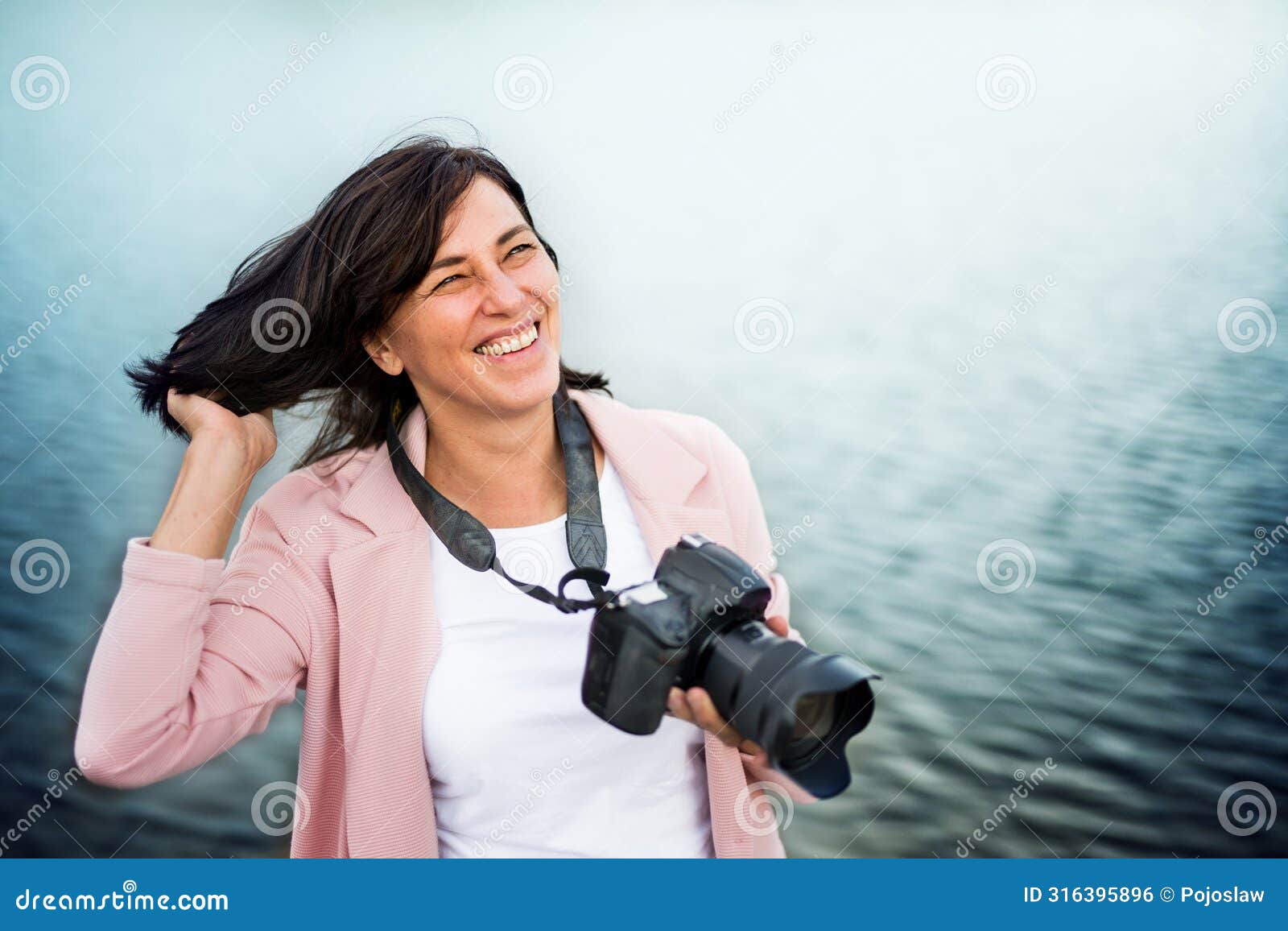 portrait of beautiful mature woman on vacation, taking photos with professional camera, capturing beauty in nature