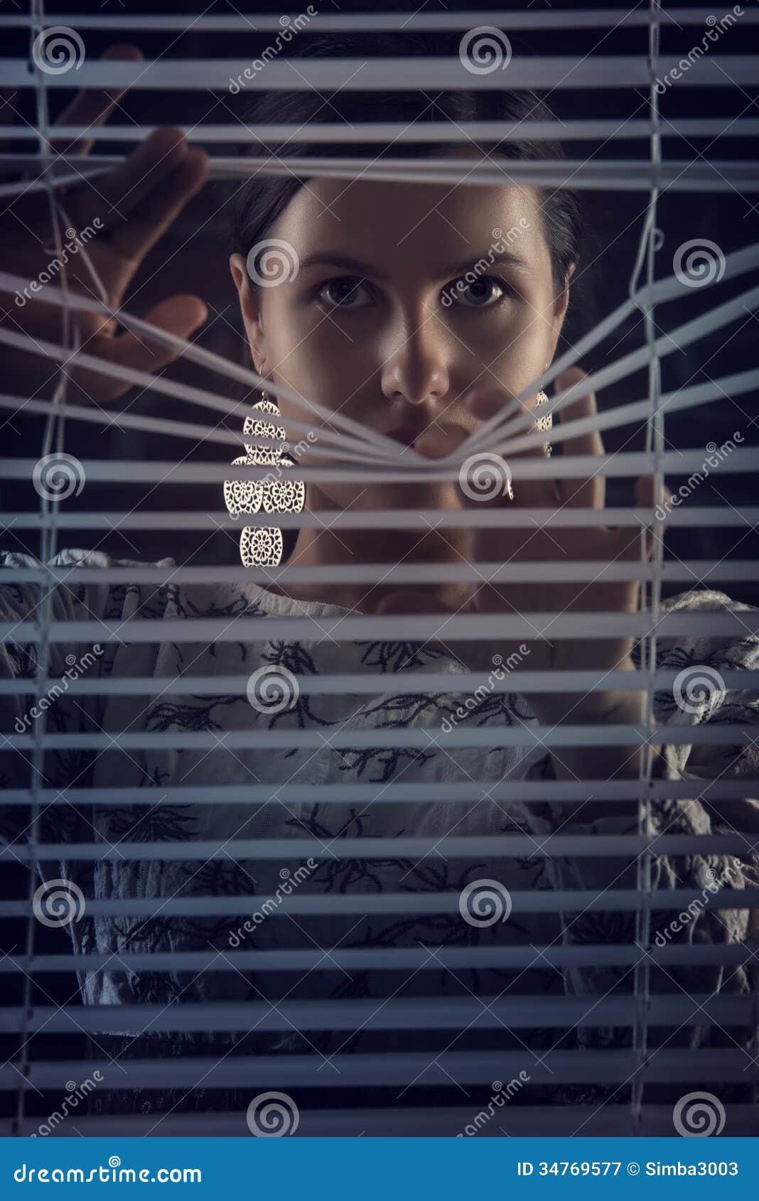 portrait of beautiful mysterious woman looking through jalousie,louver