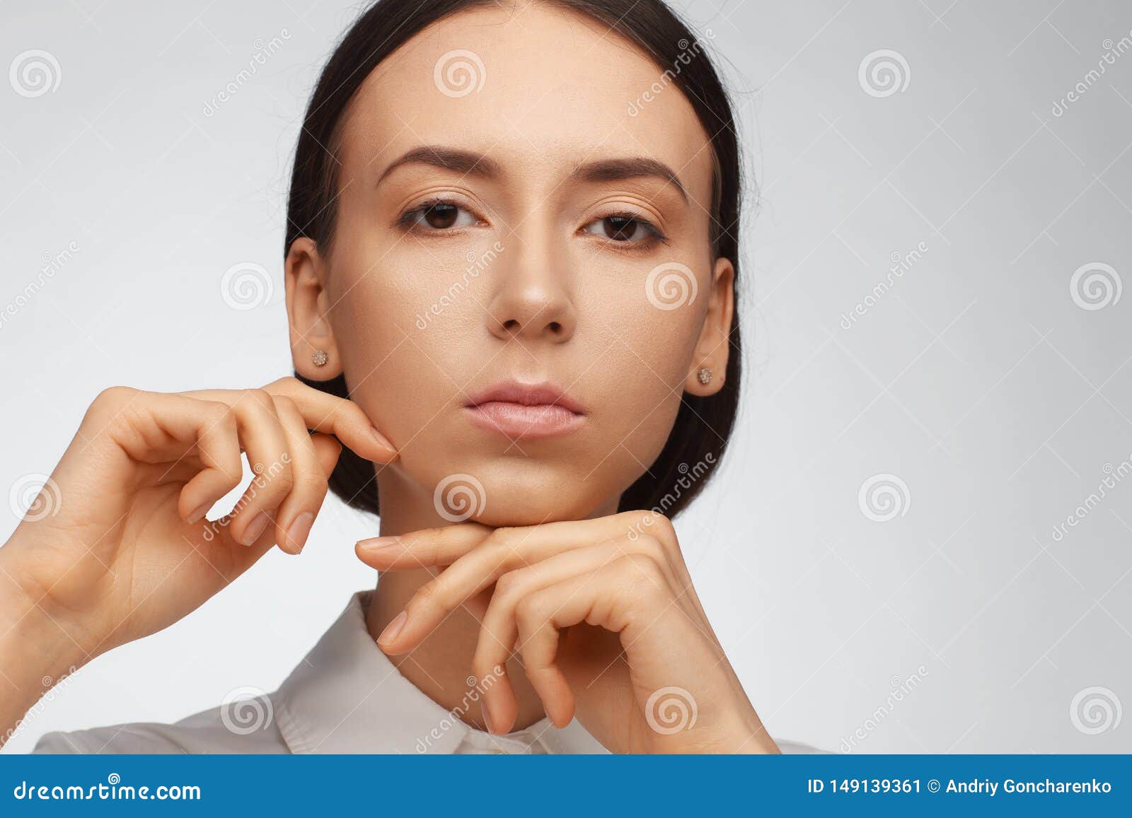 portrait of a beautiful pacified woman in a white shirt on a light background