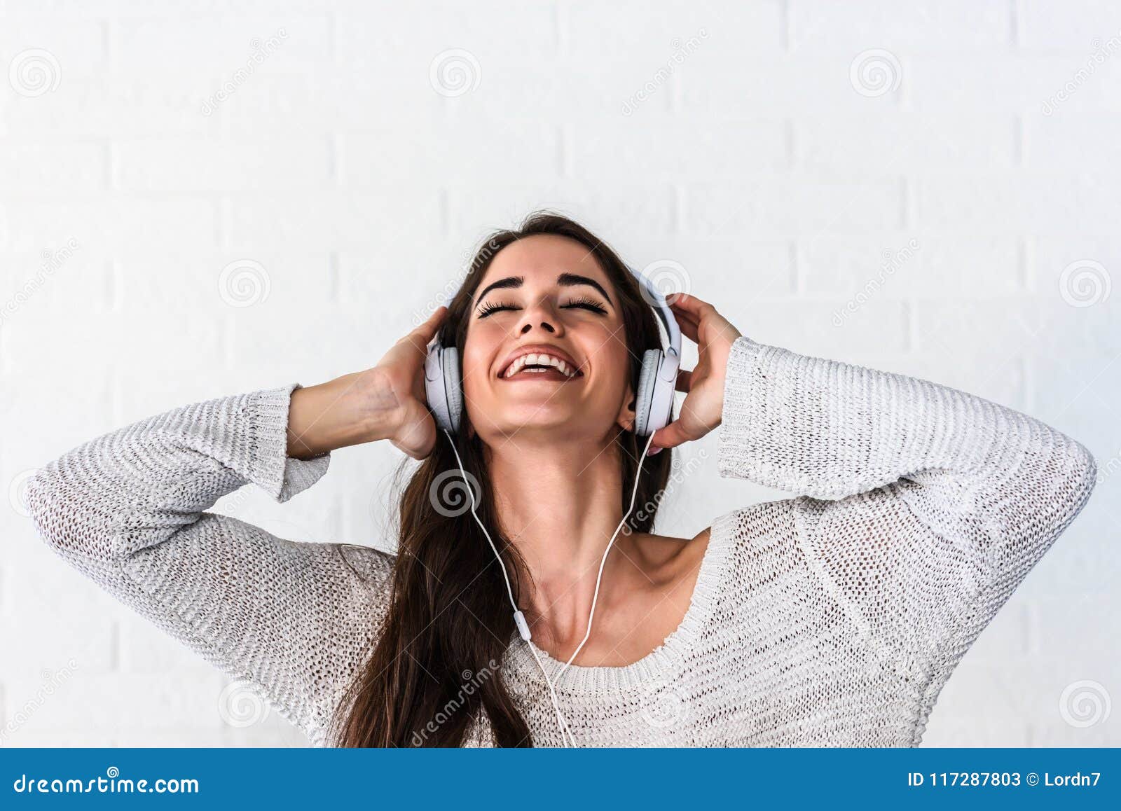 Portrait Of Beautiful Smiling Young Woman With Headphones Indoors