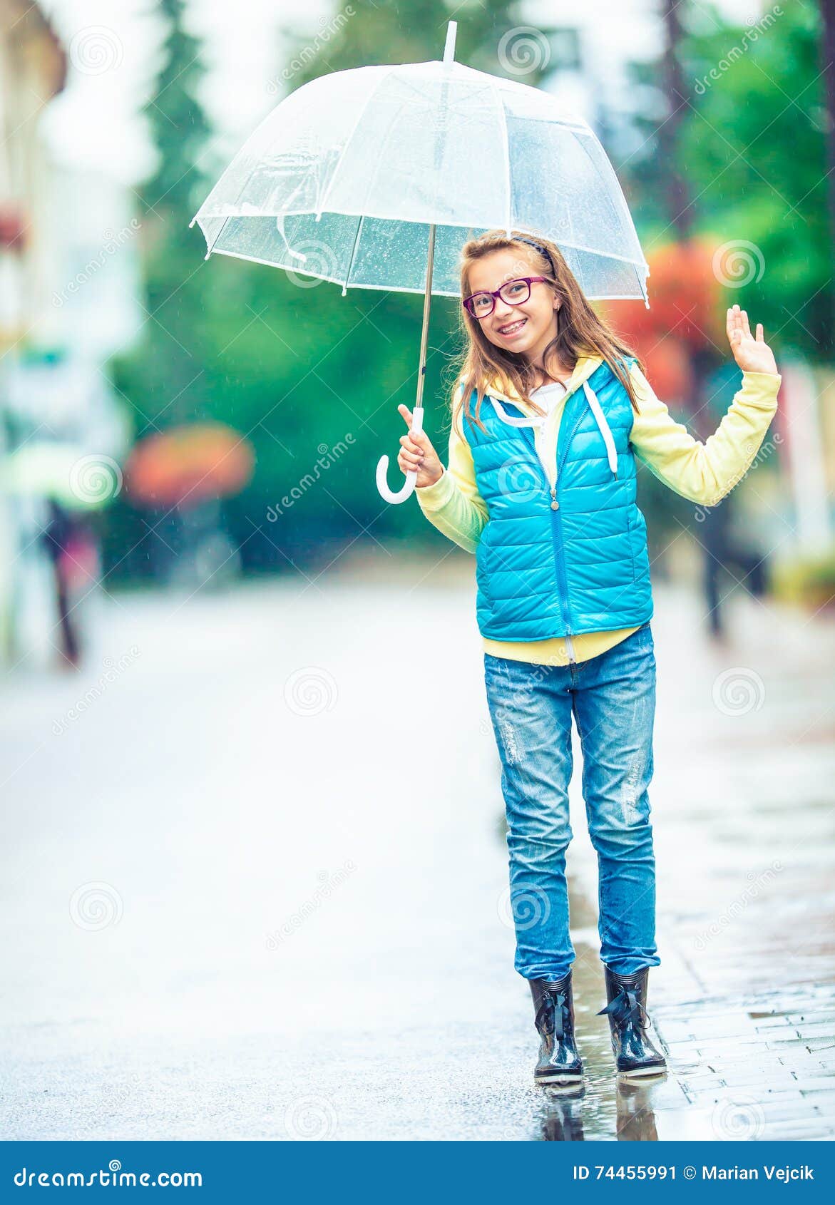 portrait of beautiful young pre-teen girl with umbrella under rain