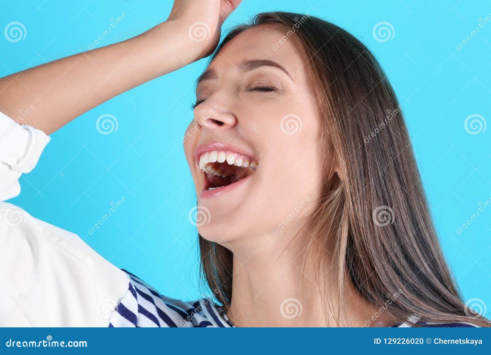 portrait of beautiful young woman bursting into laughter