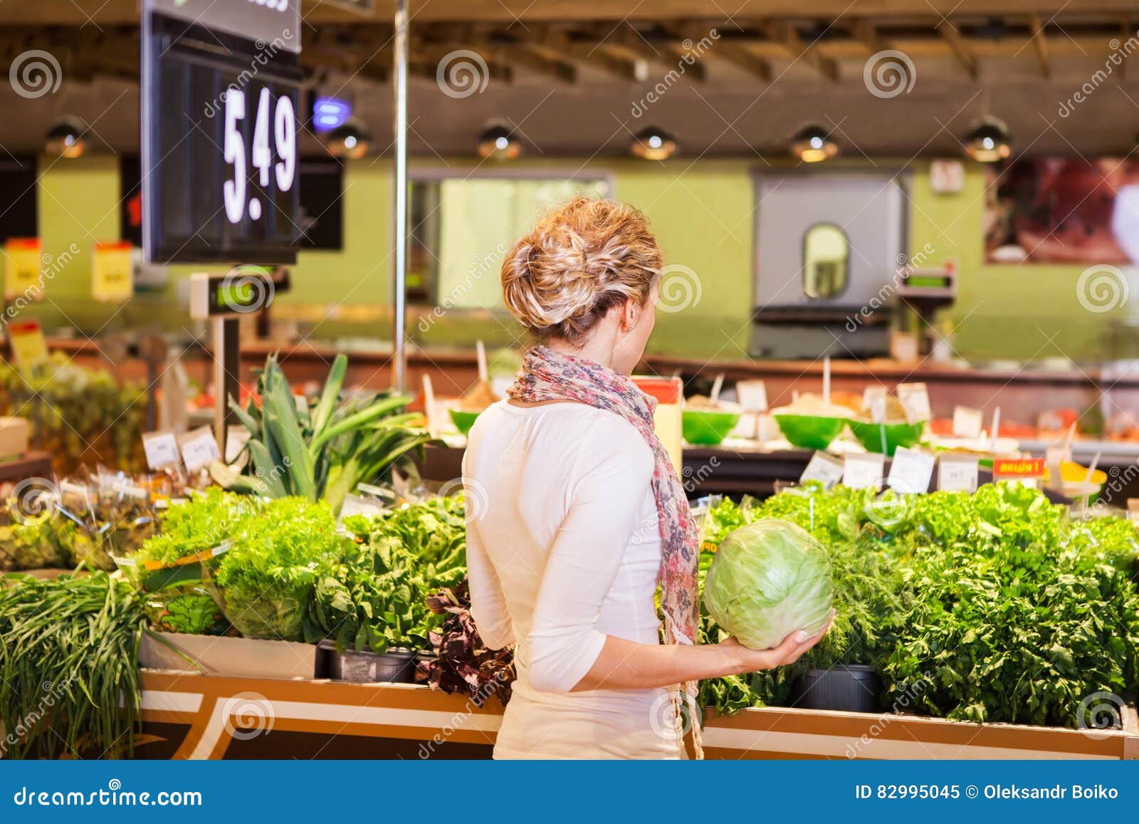 portrait of beautiful young woman choosing green leafy vegetable