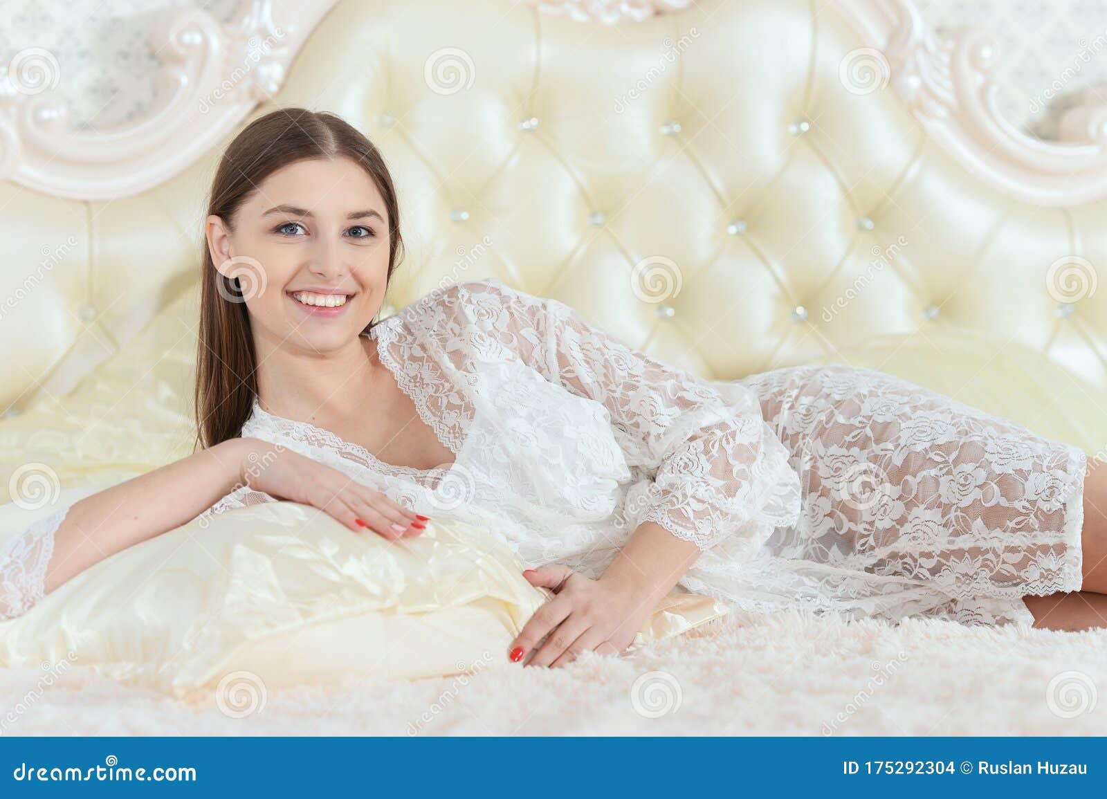 Beautiful Young Woman Lying on Soft Beige Bed at Morning Stock Photo ...