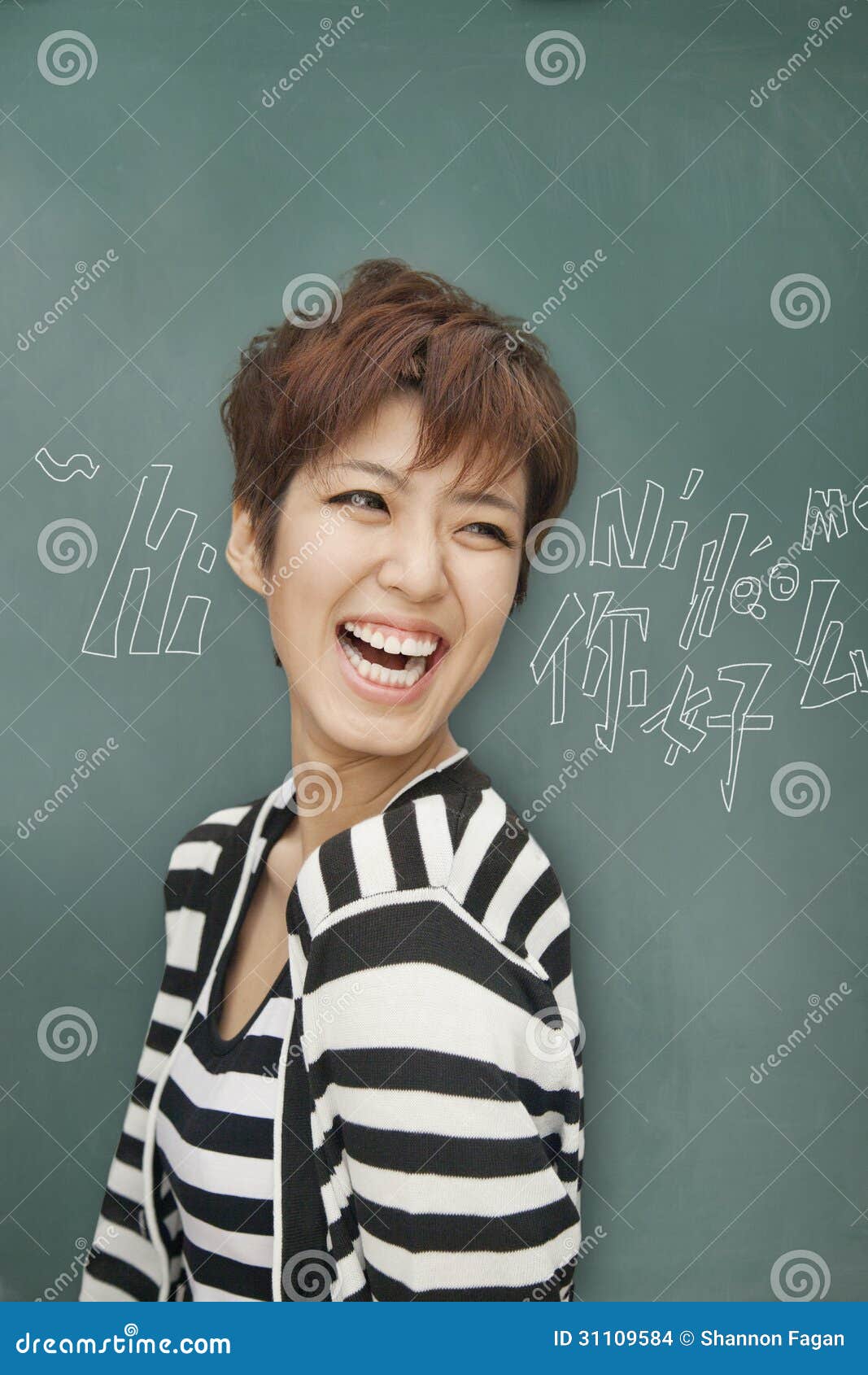 portrait of bilingual woman laughing in front of blackboard