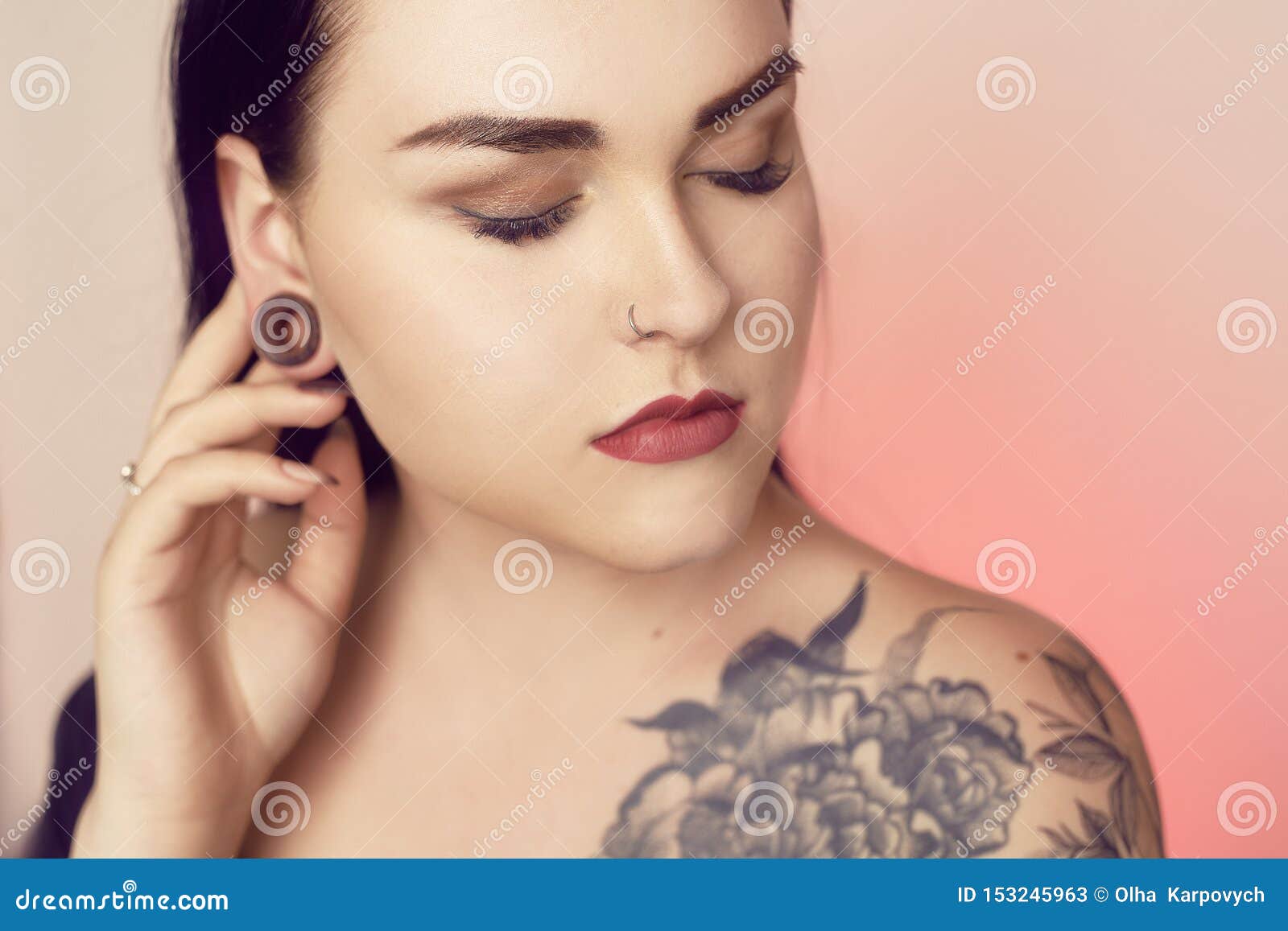 Premium PSD | Not knowing smiling young woman with tattoos and nose  piercing standing in tank top