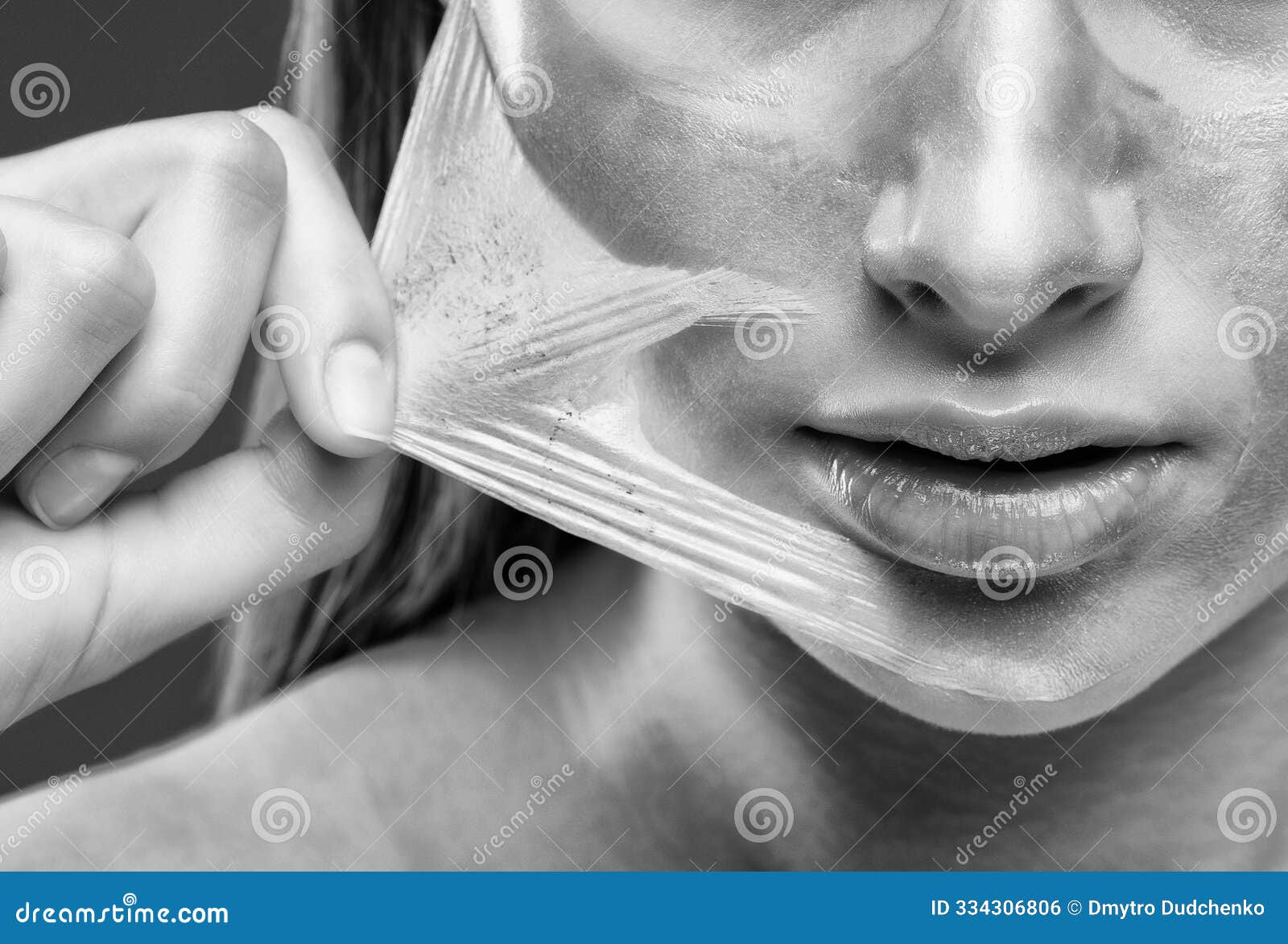 portrait of a brunette woman who makes a golden mask on her face, neck and collarbones against aging, sagging skin and skin care.