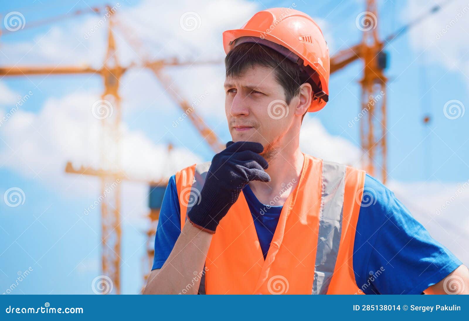 Portrait of Builder in Hard Hat and Vest at Construction Site. Young