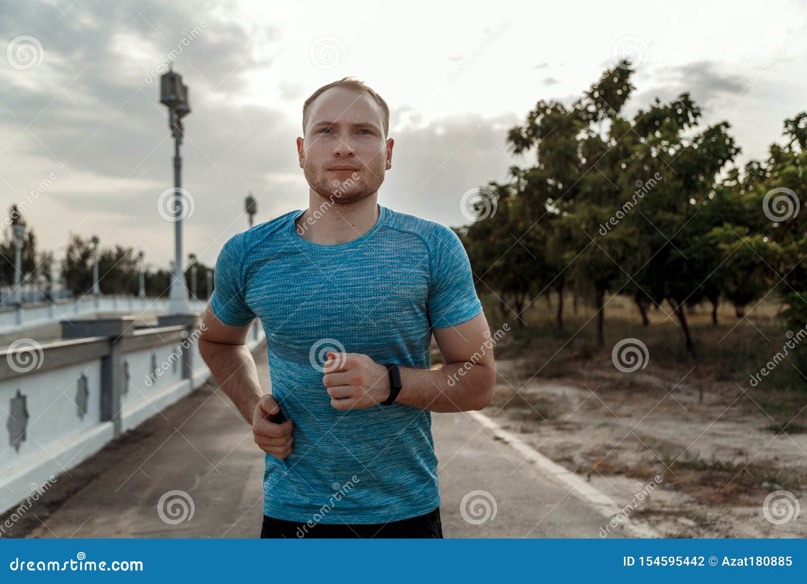 Portrait of Caucasian Guy in a Blue T-shirt and Black Shorts Who Trains ...