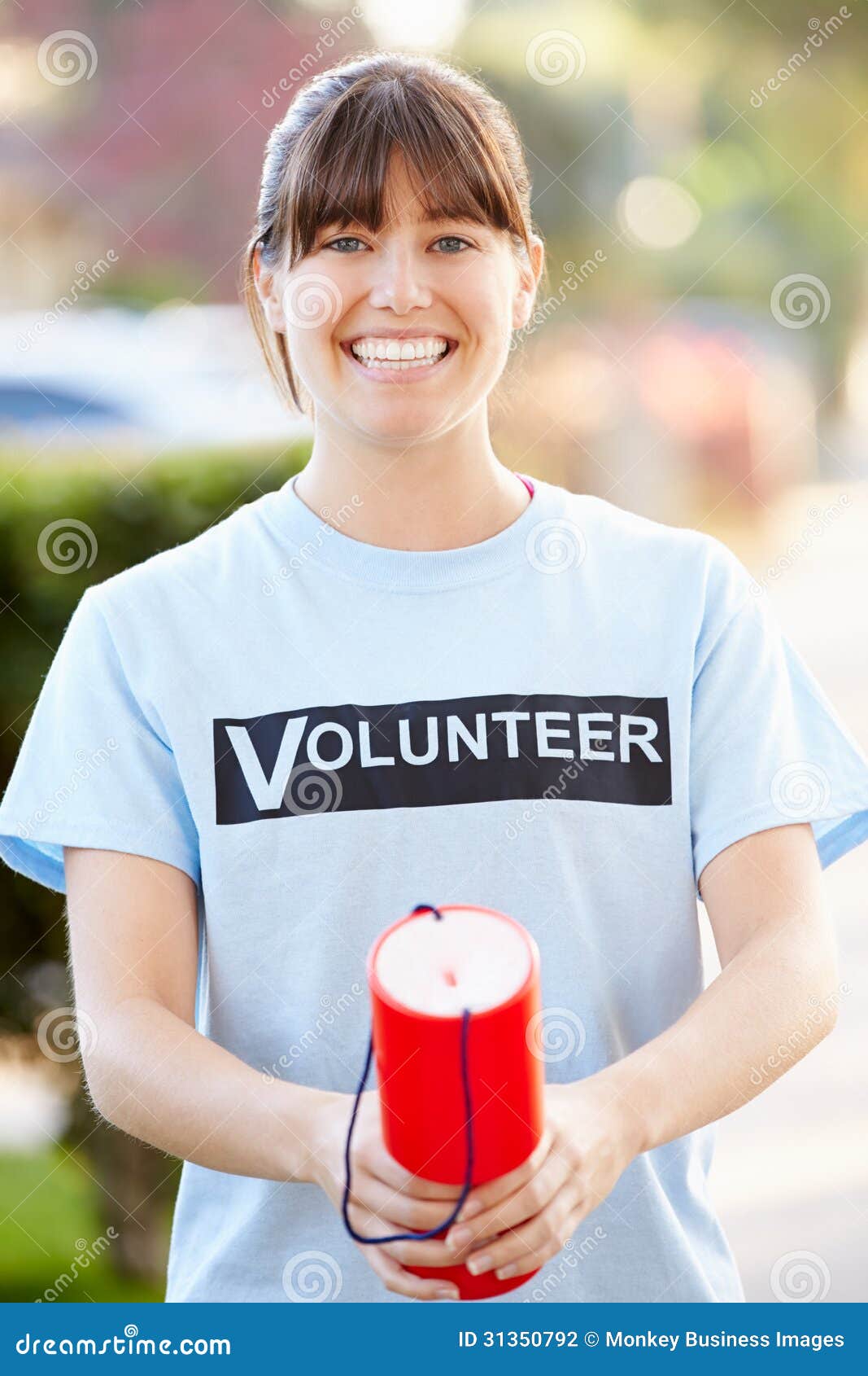 portrait of charity volunteer on street with collection tin