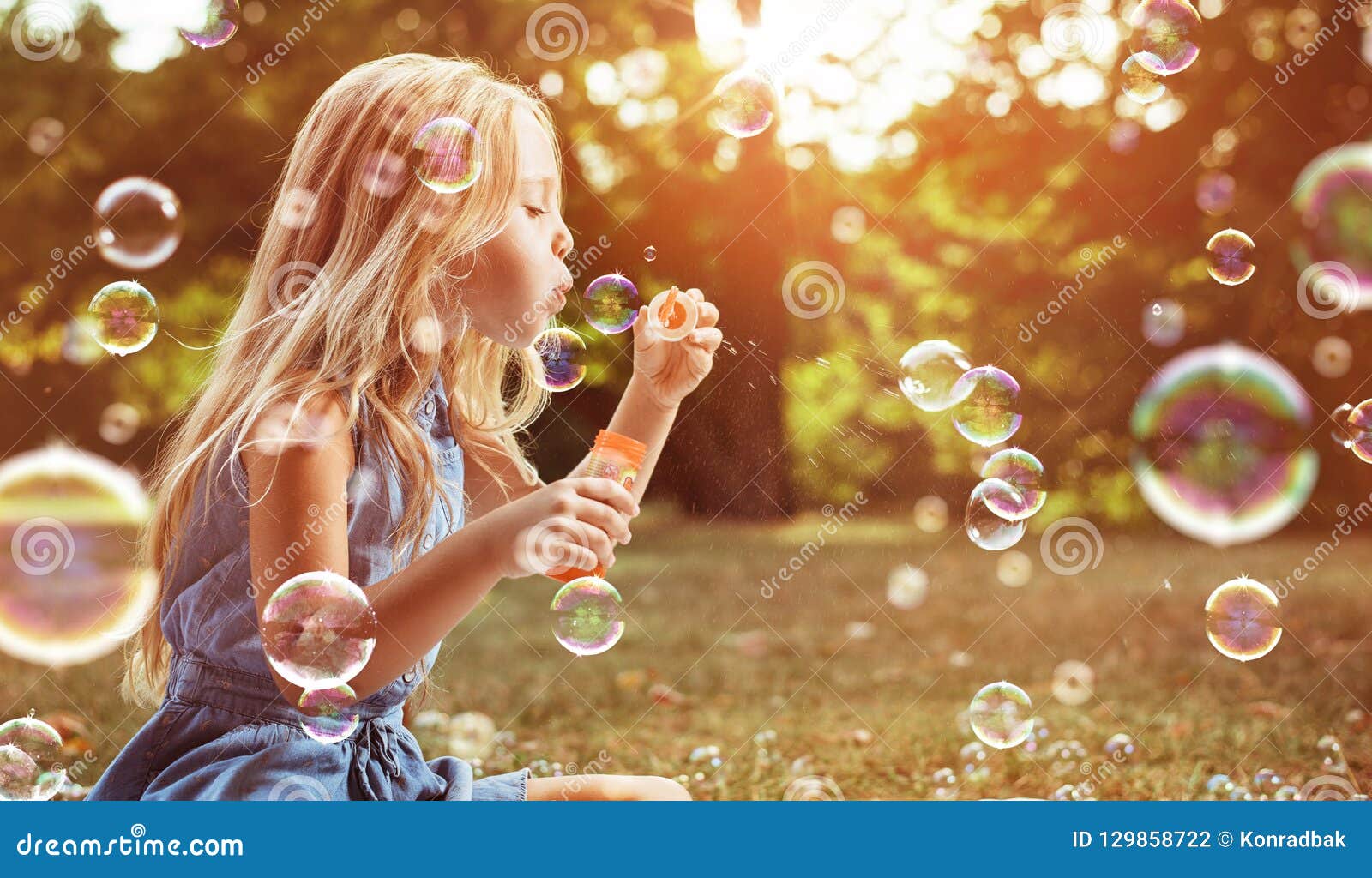 portrait of a cheerful girl blowing soap bubbles