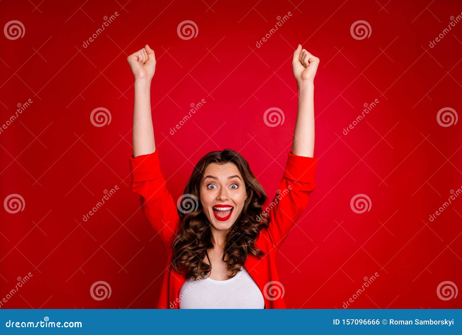 portrait of cheerful girl raising her fists screaming omg wow celebrating victory  over red background