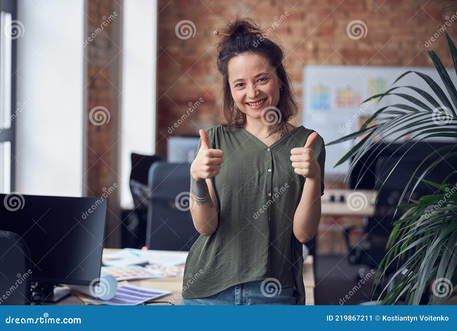 portrait of cheerful woman, interior er or architect smiling at camera, showing thums up while standing in modern