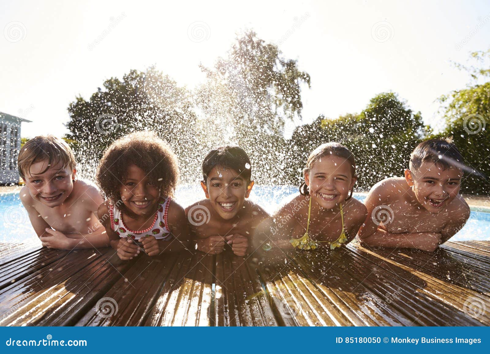 portrait of children having fun in outdoor swimming pool