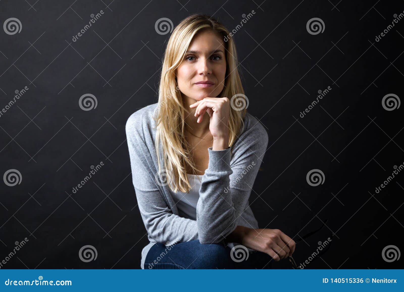 confident young woman looking at camera over black background