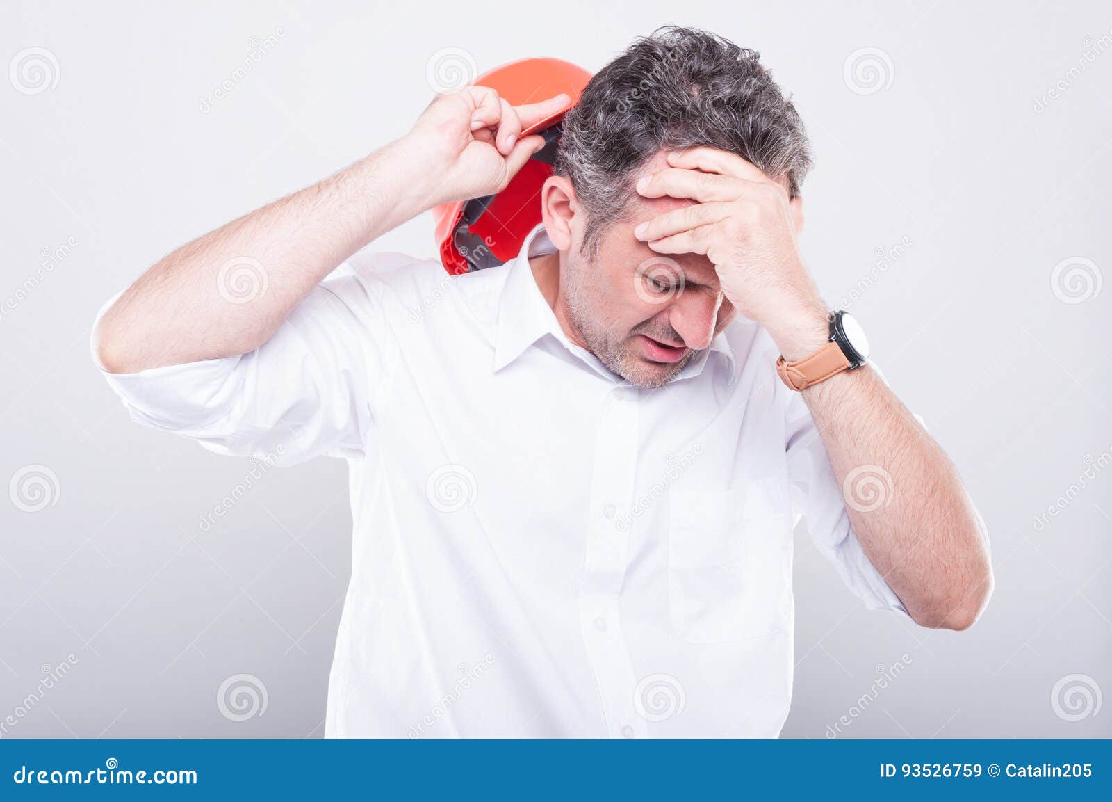 Surreptitious Gesture With The Head Portrait of Contractor Wearing Hardhat Making Head Ache Gesture Stock