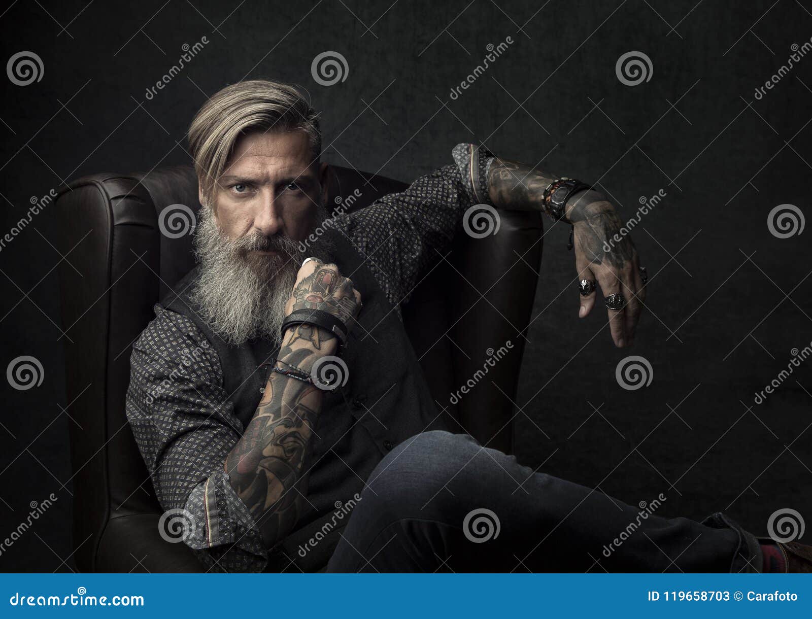 portrait of a cool bearded businessman, who is sitting on an armchair