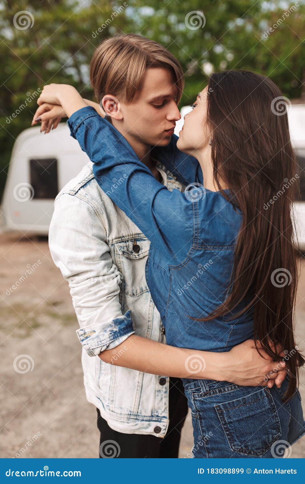 Portrait Of Cool Couple Embracing And Kissing Each Other While Standing