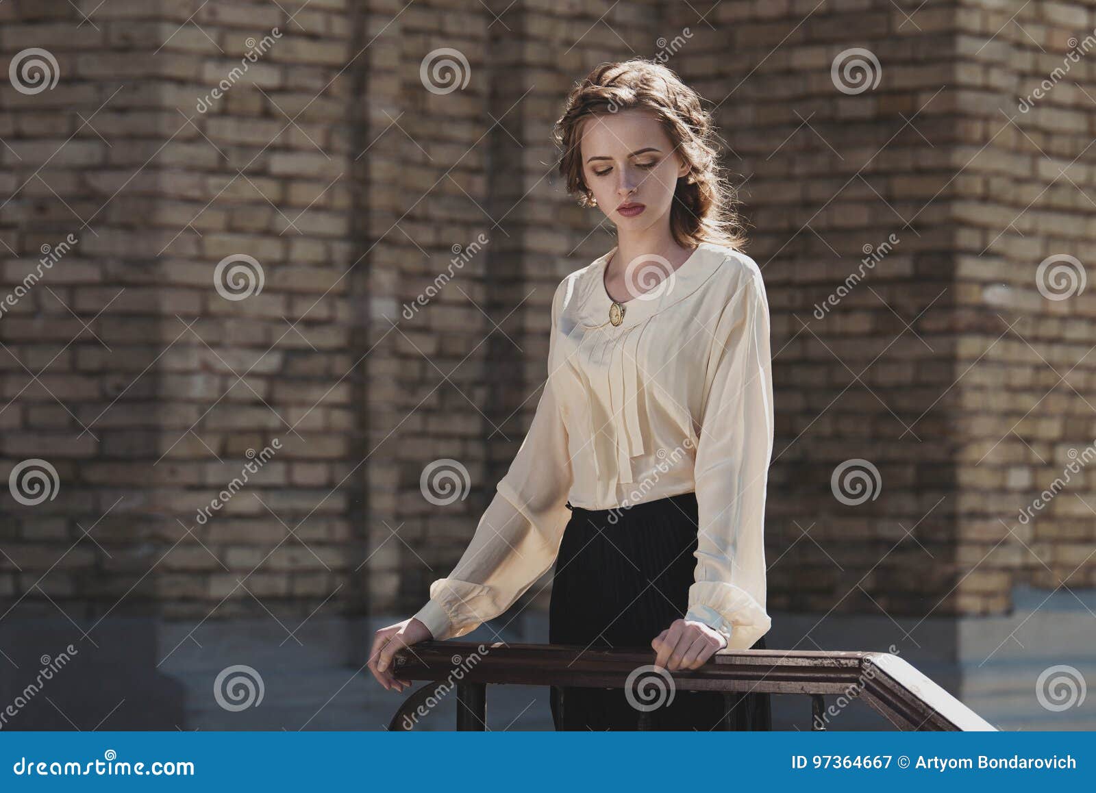 portrait of a cute dreamy girl wearing retro blouse and skirt outdoors. soft vintage toning.