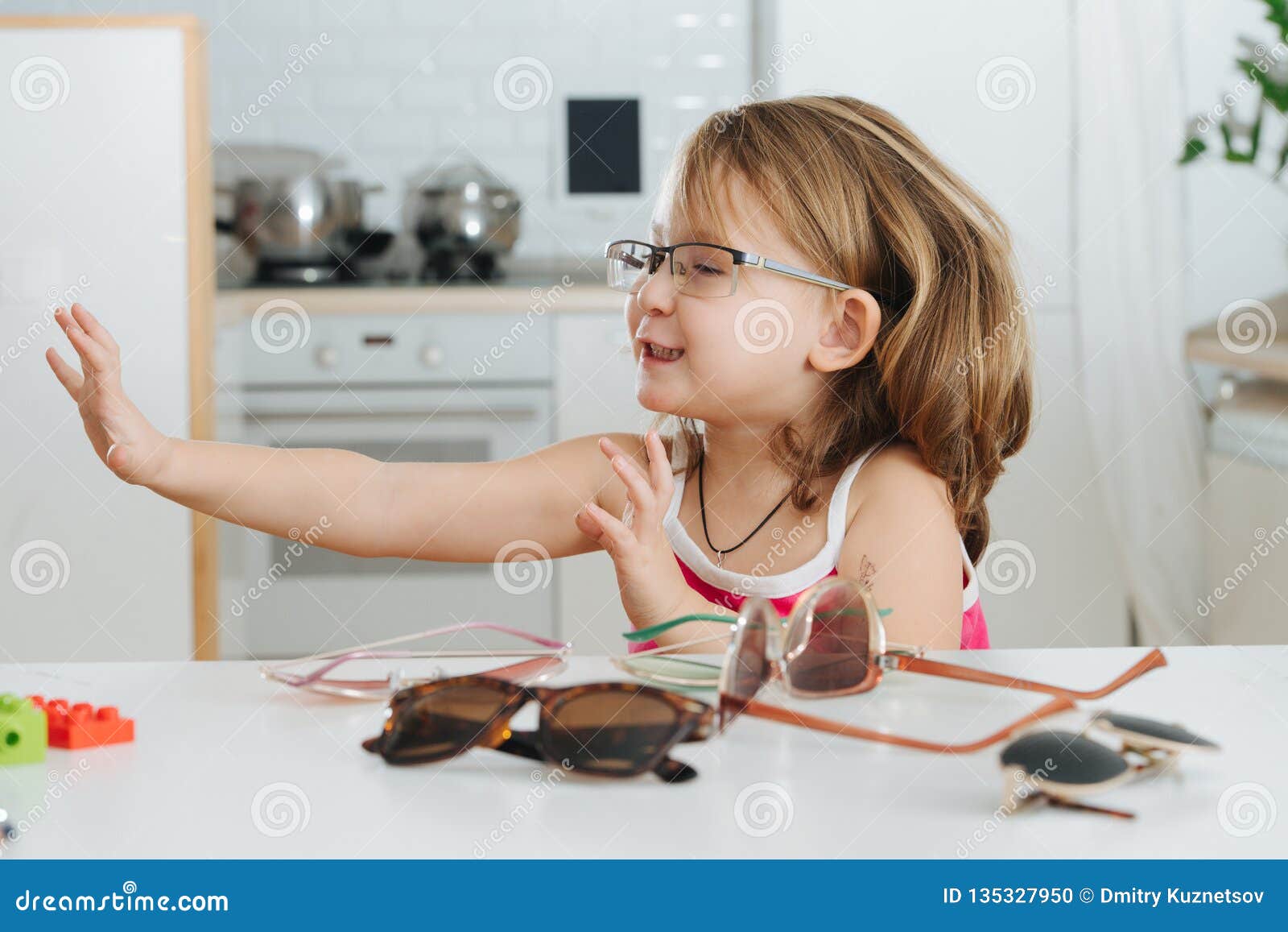 Portrait Of Cute Little Girl Trying To Wear Glasses Stock