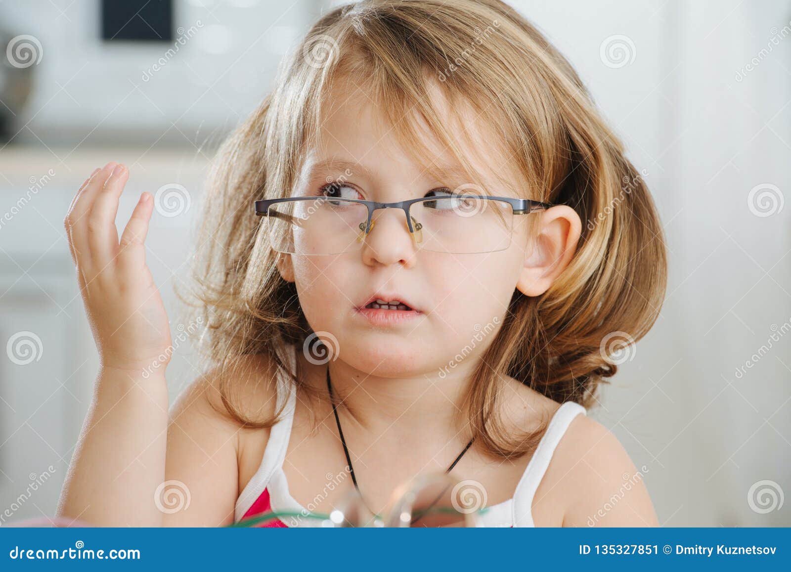 Portrait Of Cute Little Girl Trying To Wear Glasses Stock