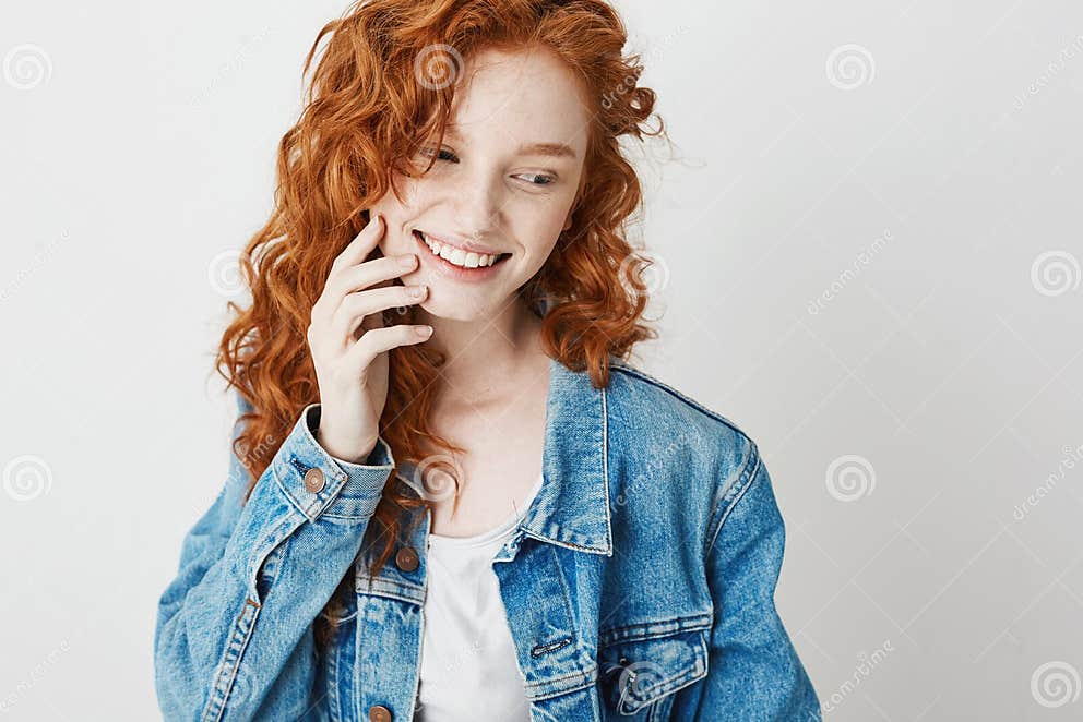 Portrait Of Cute Shy Redhead Girl Smiling Looking In Side Over White Background Copy Space