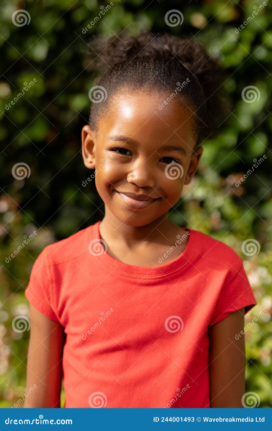 Portrait Of Cute Smiling African American Girl Standing Against Plants