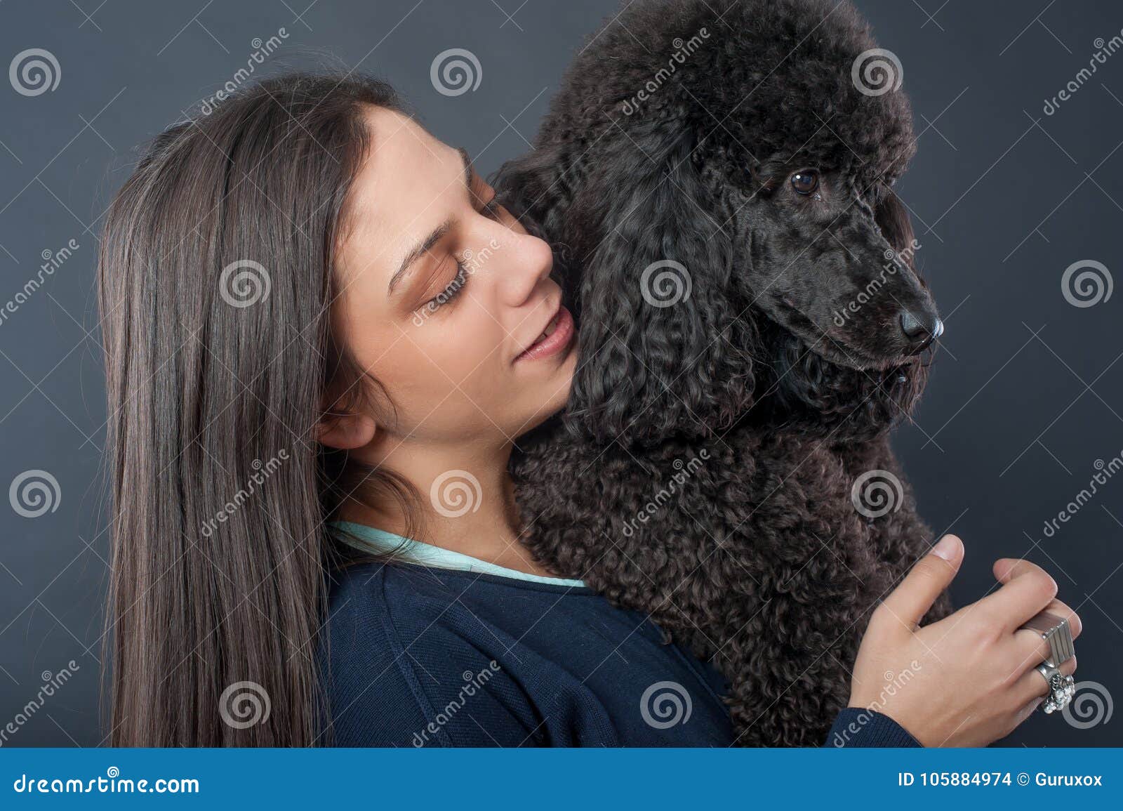 Portrait d'une belle jeune femme étreignant son beau chien Grand caniche noir Pousse de studio