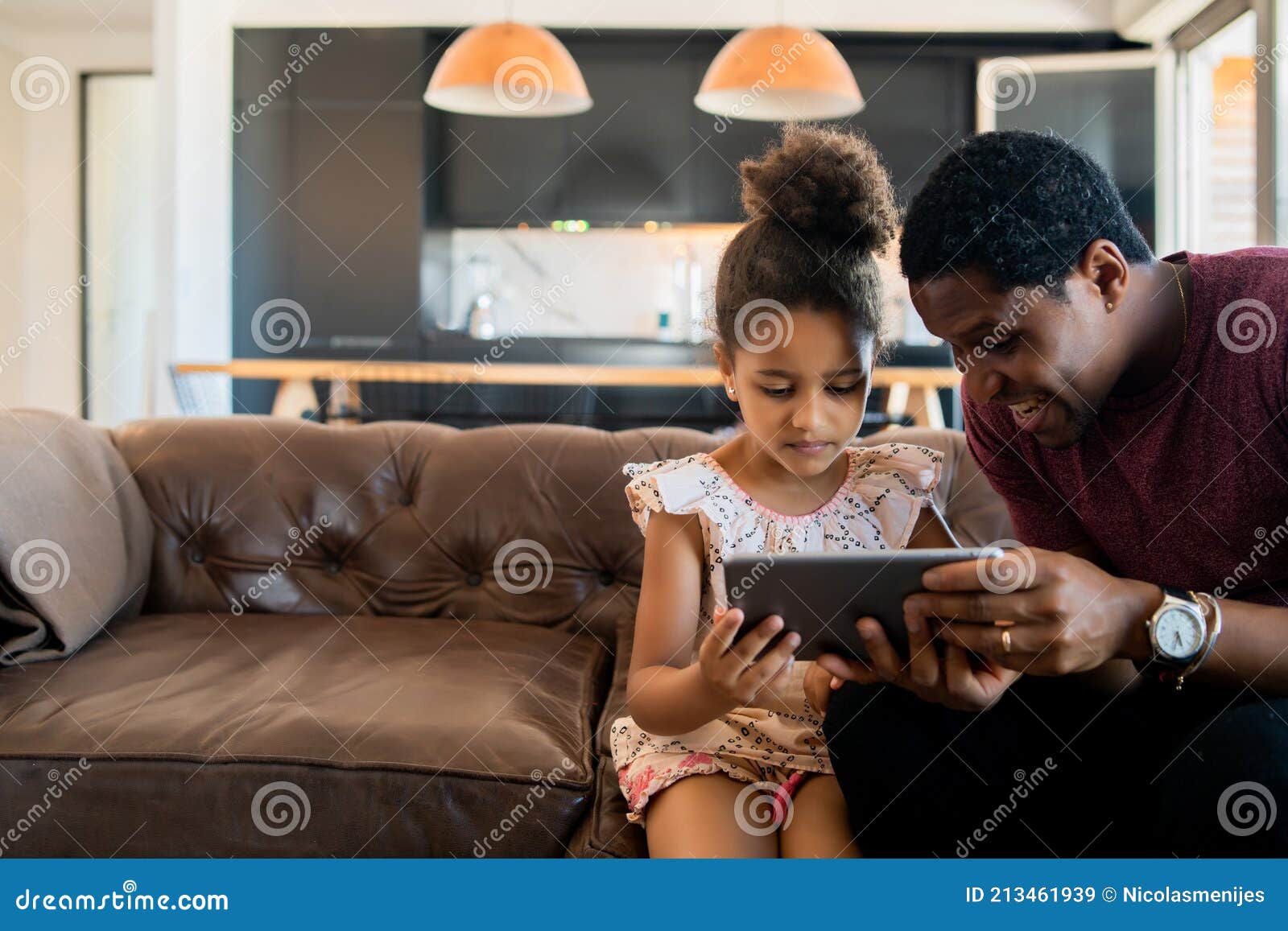 father and daughter using digital tablet at home.