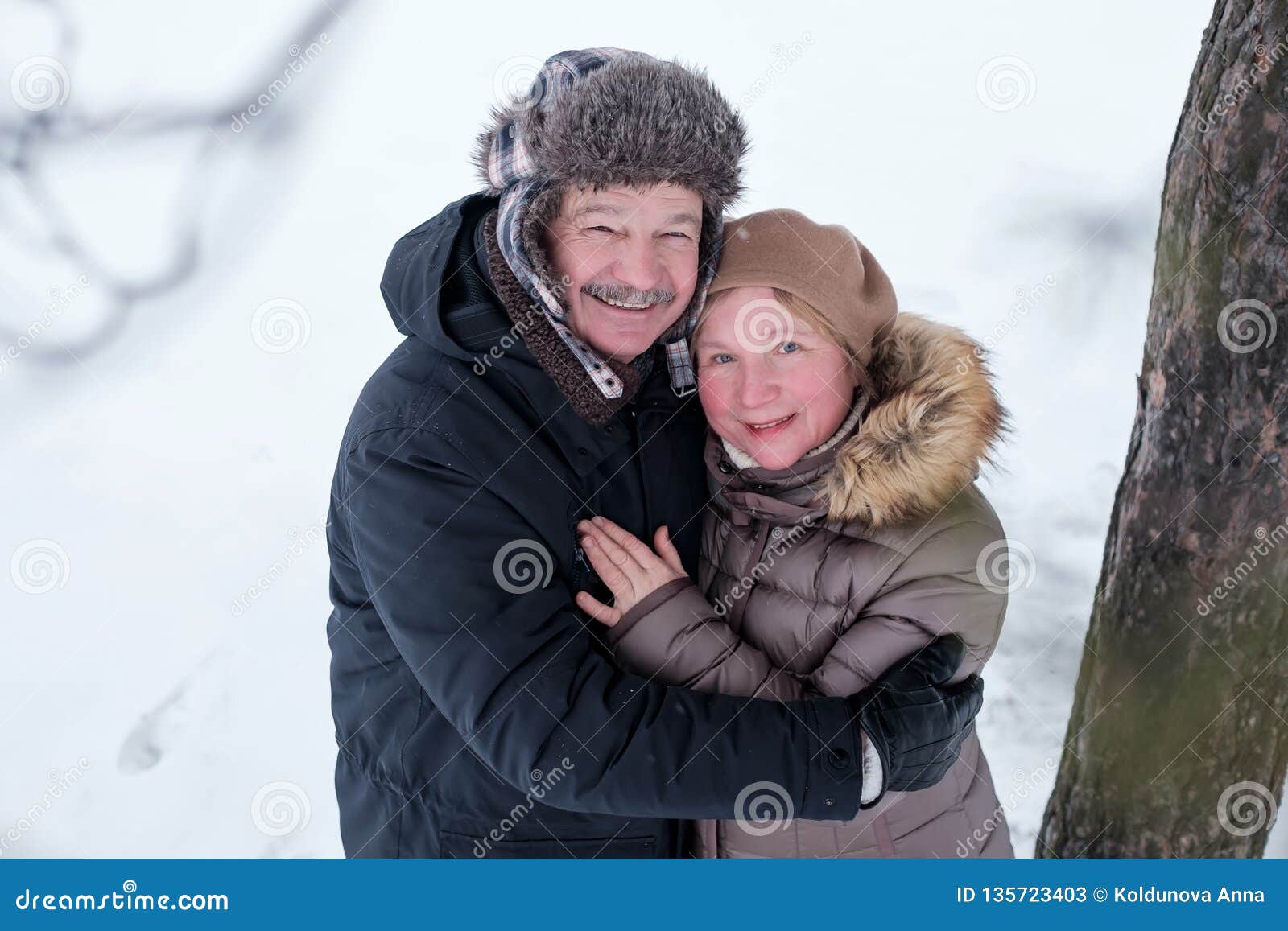 Portrait Of Elderly Couple Having Fun Outdoors In Winter Forest