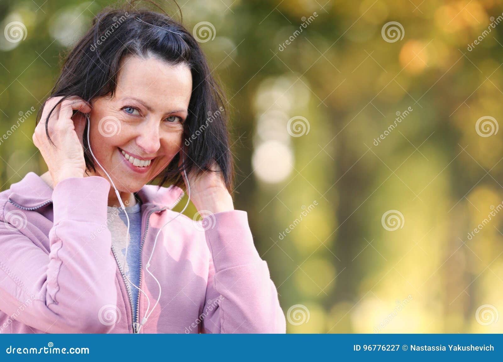 portrait of elderly woman prepare to jog with headphones in the park