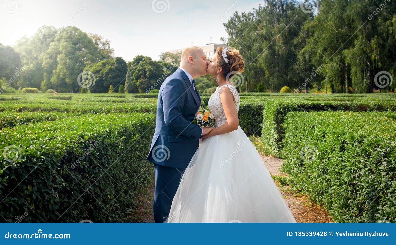 Portrait Of Elegant Newly Married Couple Kissing In Park