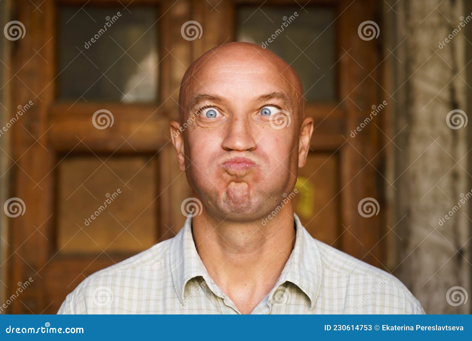 Portrait Of An Emotional Bald Guy With Blue Eyes Dressed In Light