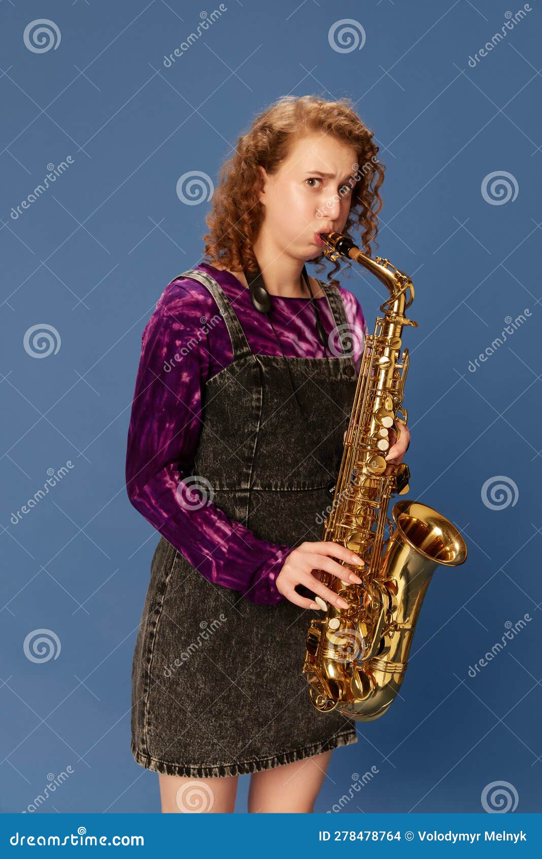 Portrait of Emotional Young Girl in Dress Playing Saxophone Against ...