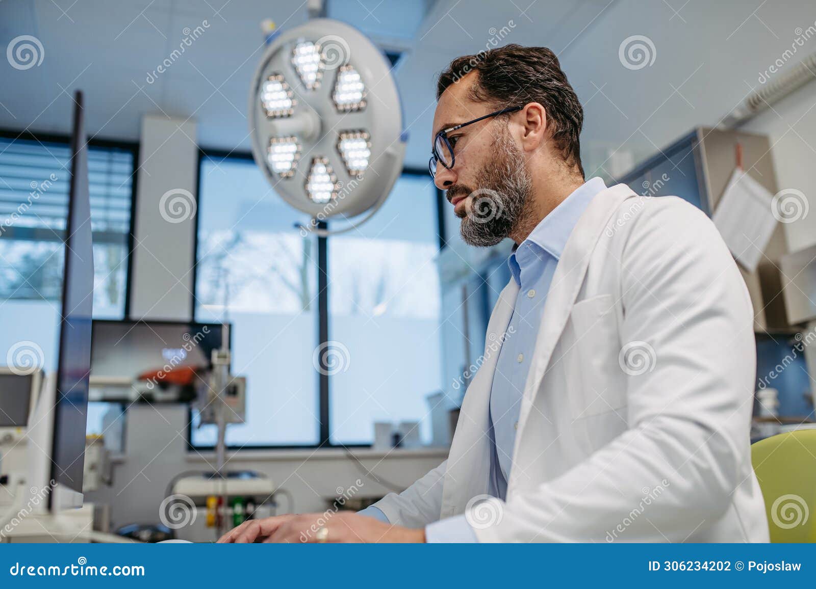 portrait of er doctor in hospital working in emergency room. healthcare worker looking at mri scan on medical computer