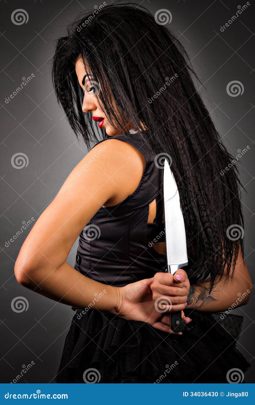 portrait of an expressive young woman holding a big knife to her