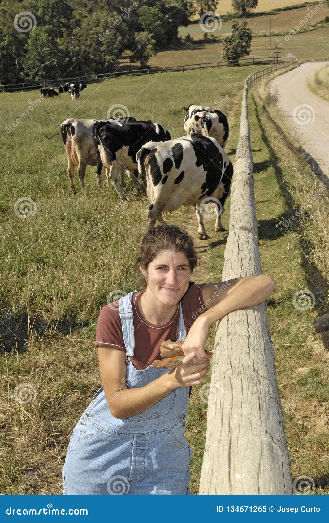 portrait of a farmer with her cows in the field